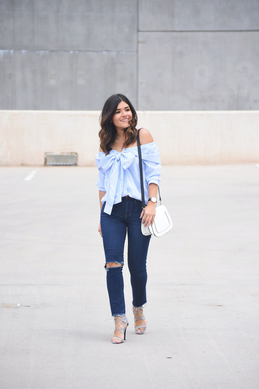 Carolina Hellal of Chic Talk wearing a tie front off the shoulder top via SheIn, Madewell jeans, and grey lace up sandals via Public Desire.