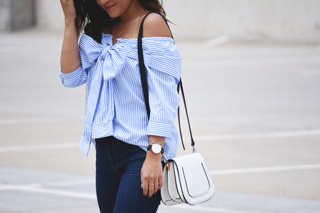 Carolina Hellal of Chic Talk wearing a SheIn blue striped off the shoulder top and a Solesociety white crossbody bag