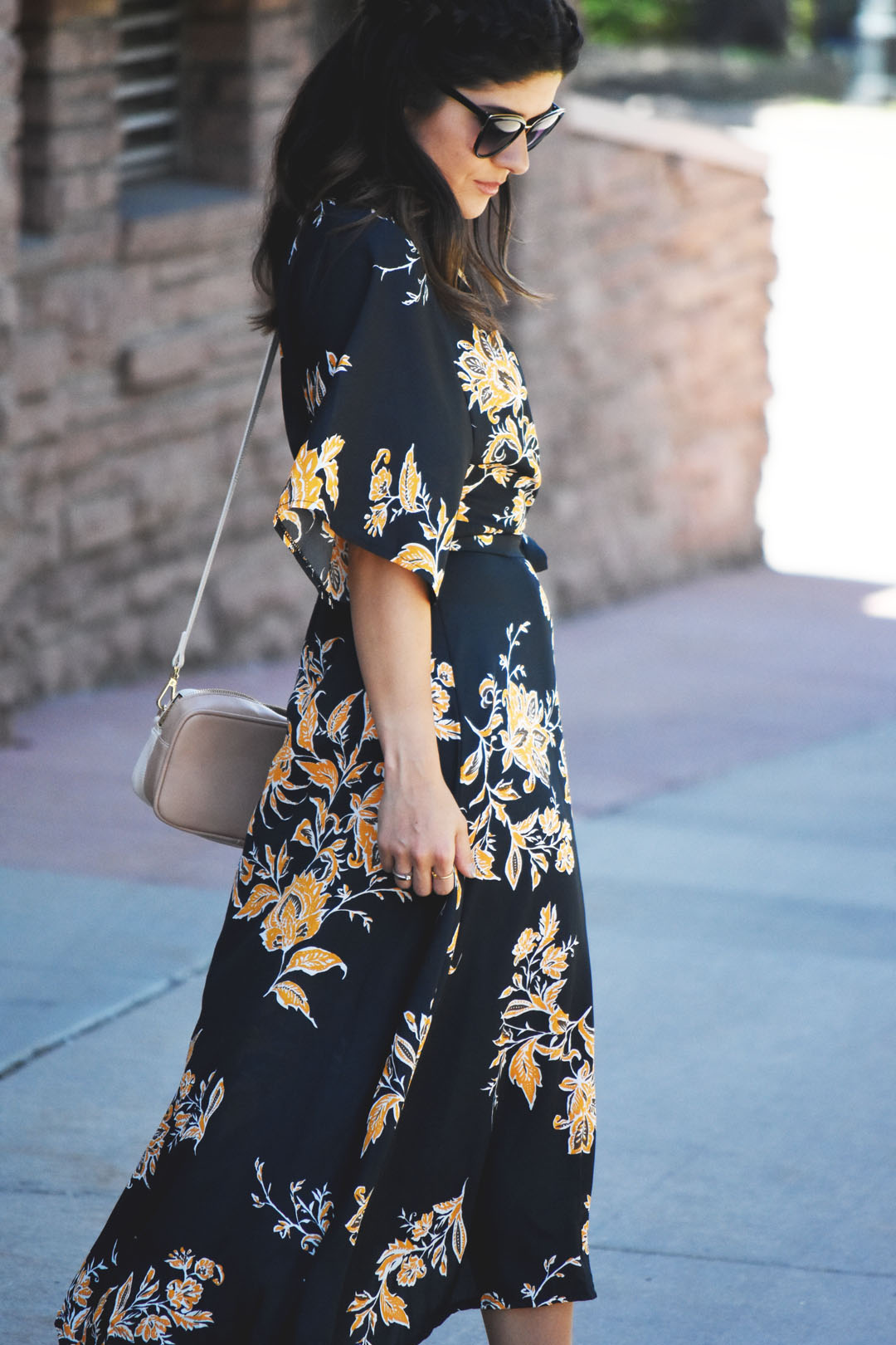 Carolina Hellal of Chic Talk wearing a floral wrap maxi dress, Nordstrom sunglasses, and Pueblo L.A dainty gold rings.