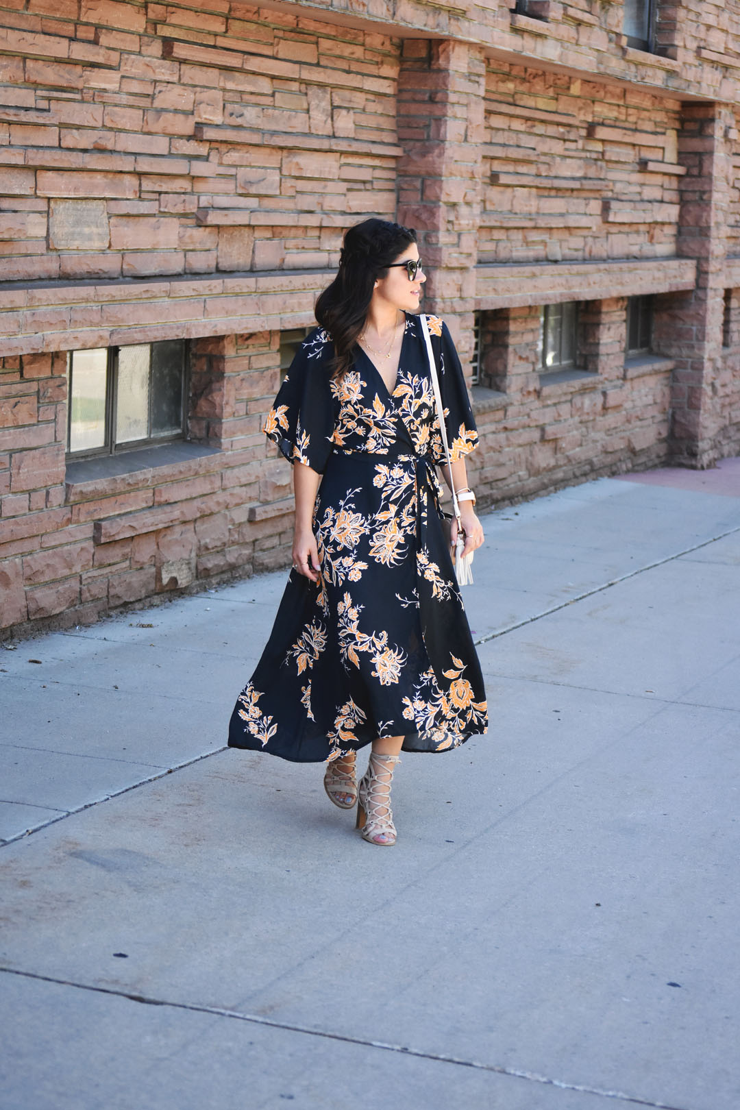 Carolina Hellal of Chic Talk wearing a wrap maxi floral dress, beige lace up sandals, and h&m beige tassle crossbody bag. 