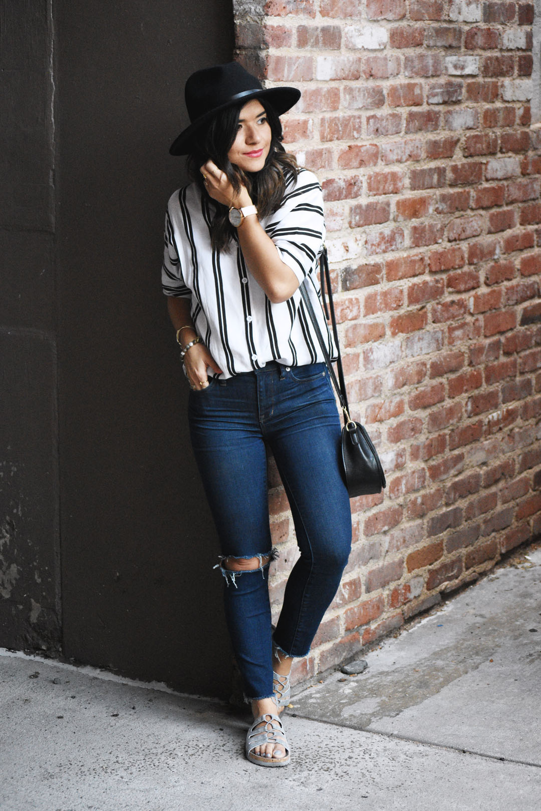 Carolina Hellal of Chic Talk wearing a stripe top, Madewell ripped jeans, and Skechers sandals
