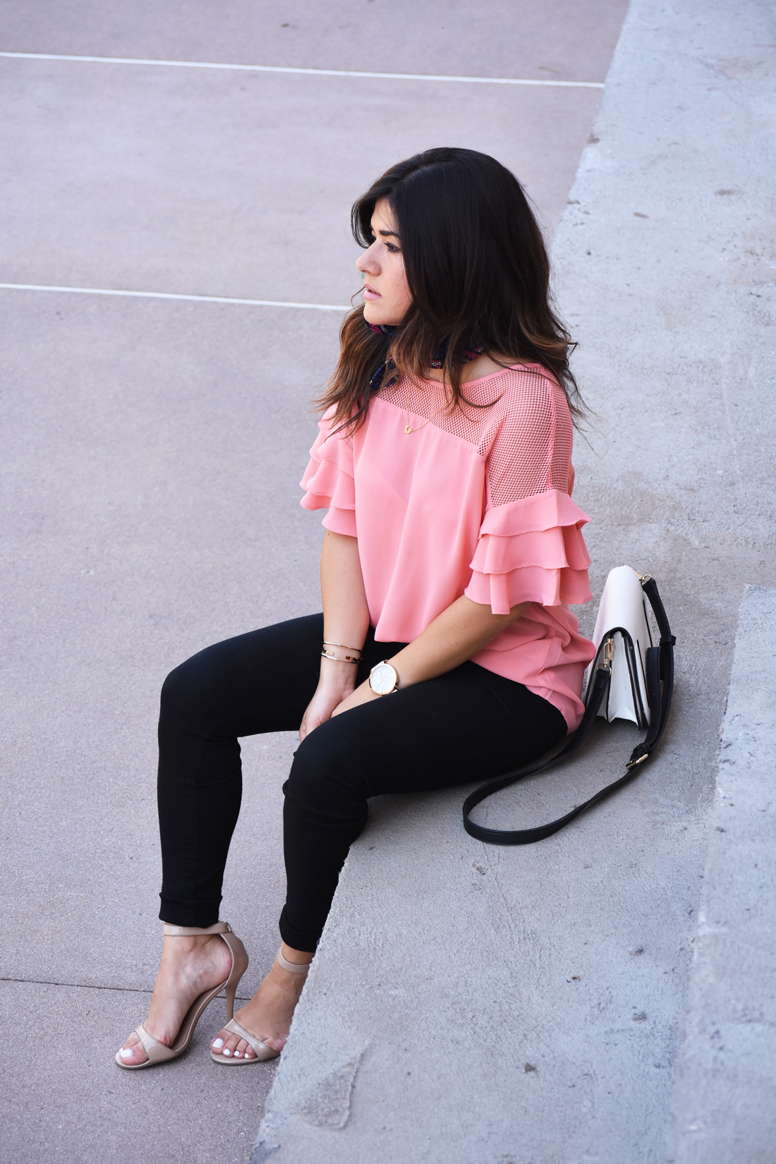 Carolina Hellal of Chic Talk wearing a VIPme pink top, Christian Paul watch, sole society bag, and Citizen of humanity black skinny jeans