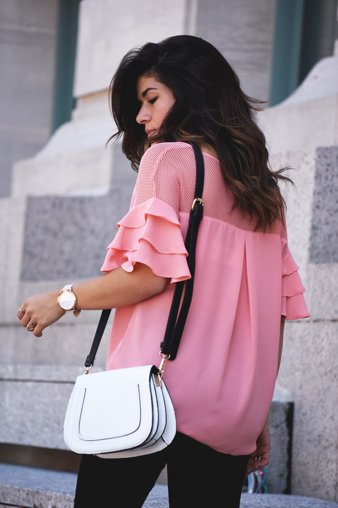 Carolina Hellal of Chic Talk wearing a VIPme pink top, Christian Paul watch, sole society bag, and Citizen of humanity black skinny jeans