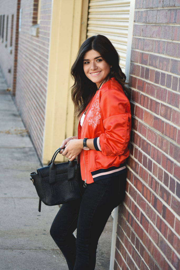 Carolina Hellal of Chic Talk wearing a red H&M bomber jacket and black Mellow handbag world crossbody bag