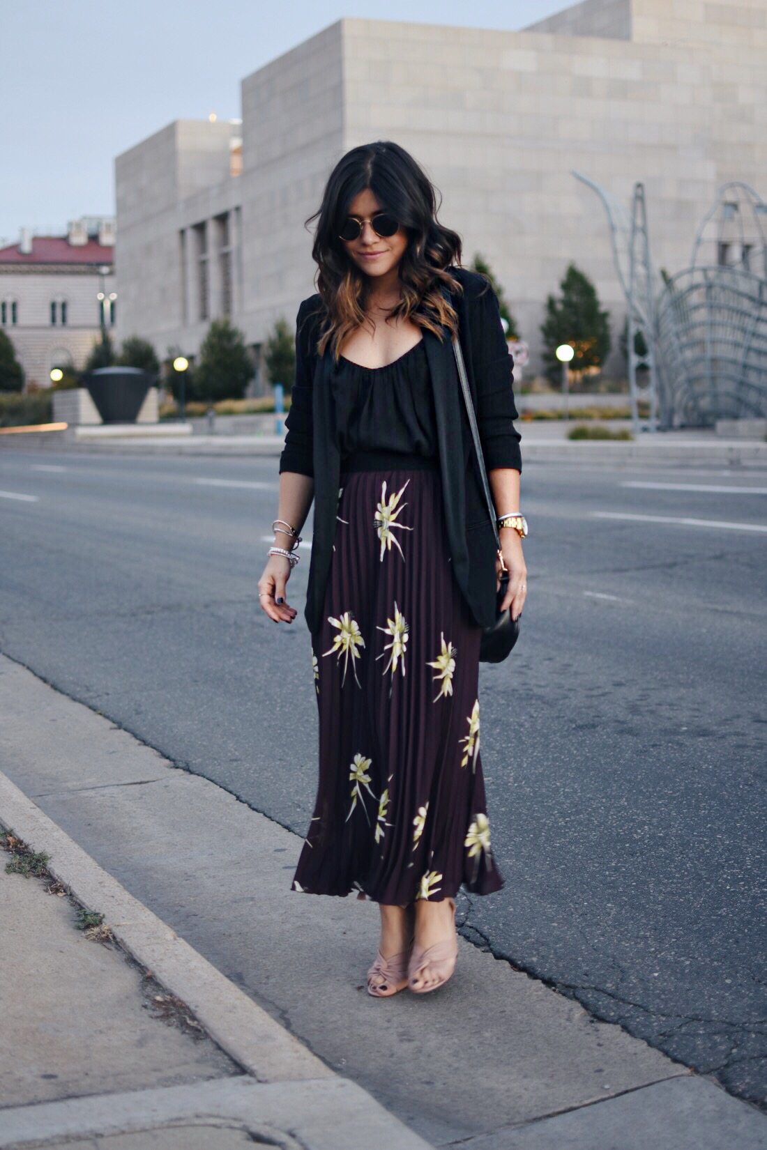 Carolina Hellal of Chic Talk wearing an H&M pleated print skirt, black blazer, and Topshop blush sandals.