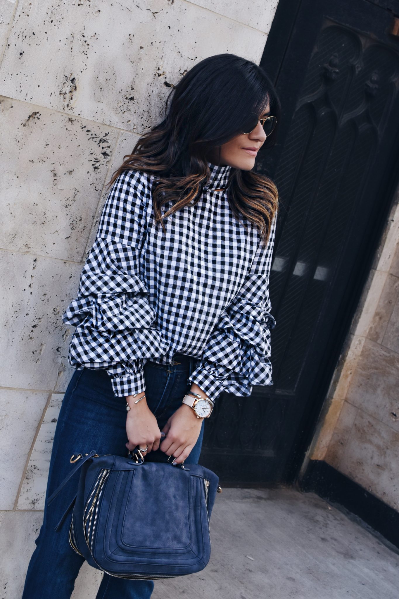 Carolina Hellal of Chic Talk wearing a Gingham top via Shein, Rayban rounded sunglasses, Levi's flare jeans and a Violet Ray suede bag