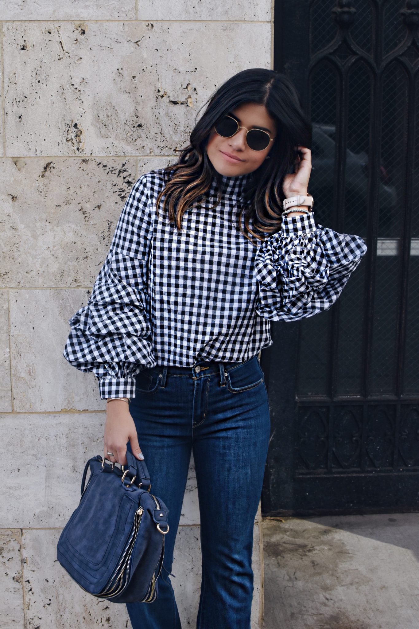 Carolina Hellal of Chic Talk wearing a Gingham top via Shein, Rayban rounded sunglasses, Levi's flare jeans and a Violet Ray suede bag