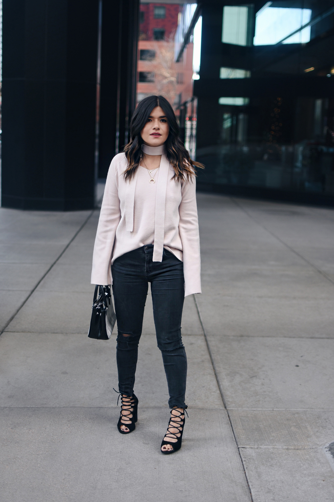 Carolina Hellal of Chic Talk wearing a Chicwish bell sleeve sweater, Madewell ripped jeans, Topshop leather jacket, and Public Desire sandals.