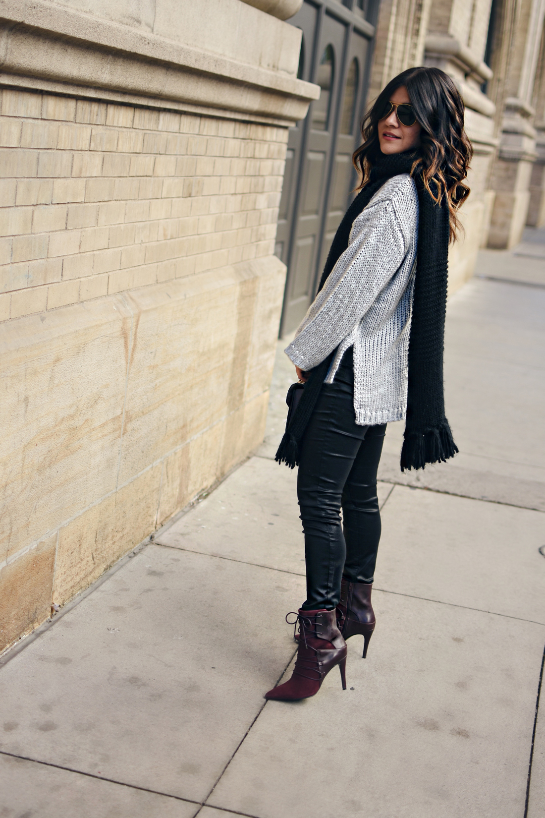 Carolina Hellal of Chic Talk wearing a Chicwish grey knit sweater, Rayban aviator sunglasses, Madewell coated skinny jeans and Nine West burgundy booties