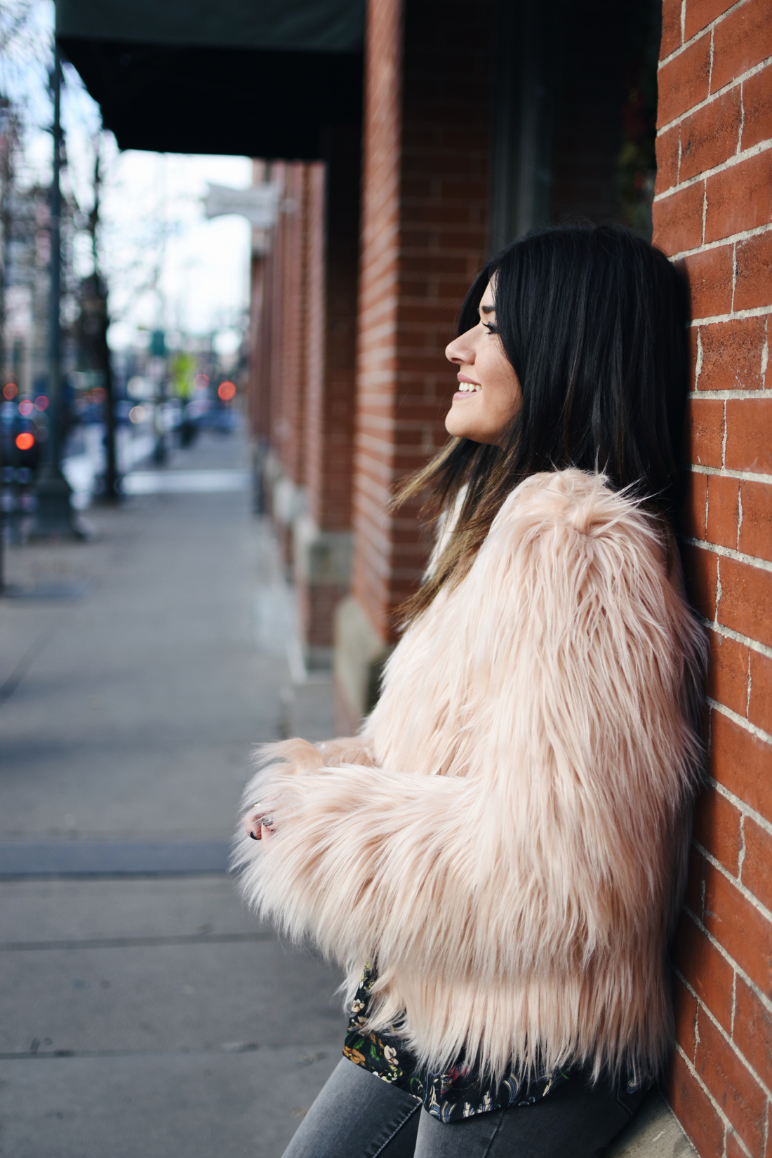 Carolina Hellal of Chic Talk wearing a floral top, furry pink coat, Madewell jeans, and h&m black booties