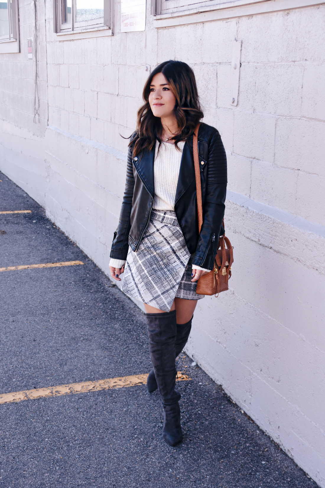Carolina Hellal of Chic Talk wearing a Chicwish camel coat, plaid skirt, Topshop faux leather jacket, and Public Desire over the knee boots