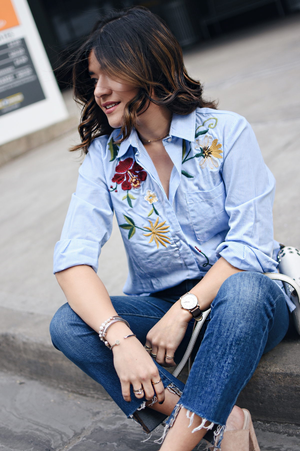 Carolina Hellal of Chic Talk wearing a Chicwish embroidered top, Madewell raw hem jeans, Frye white crossbidy bag, and NA-KD fashion nude mules. 