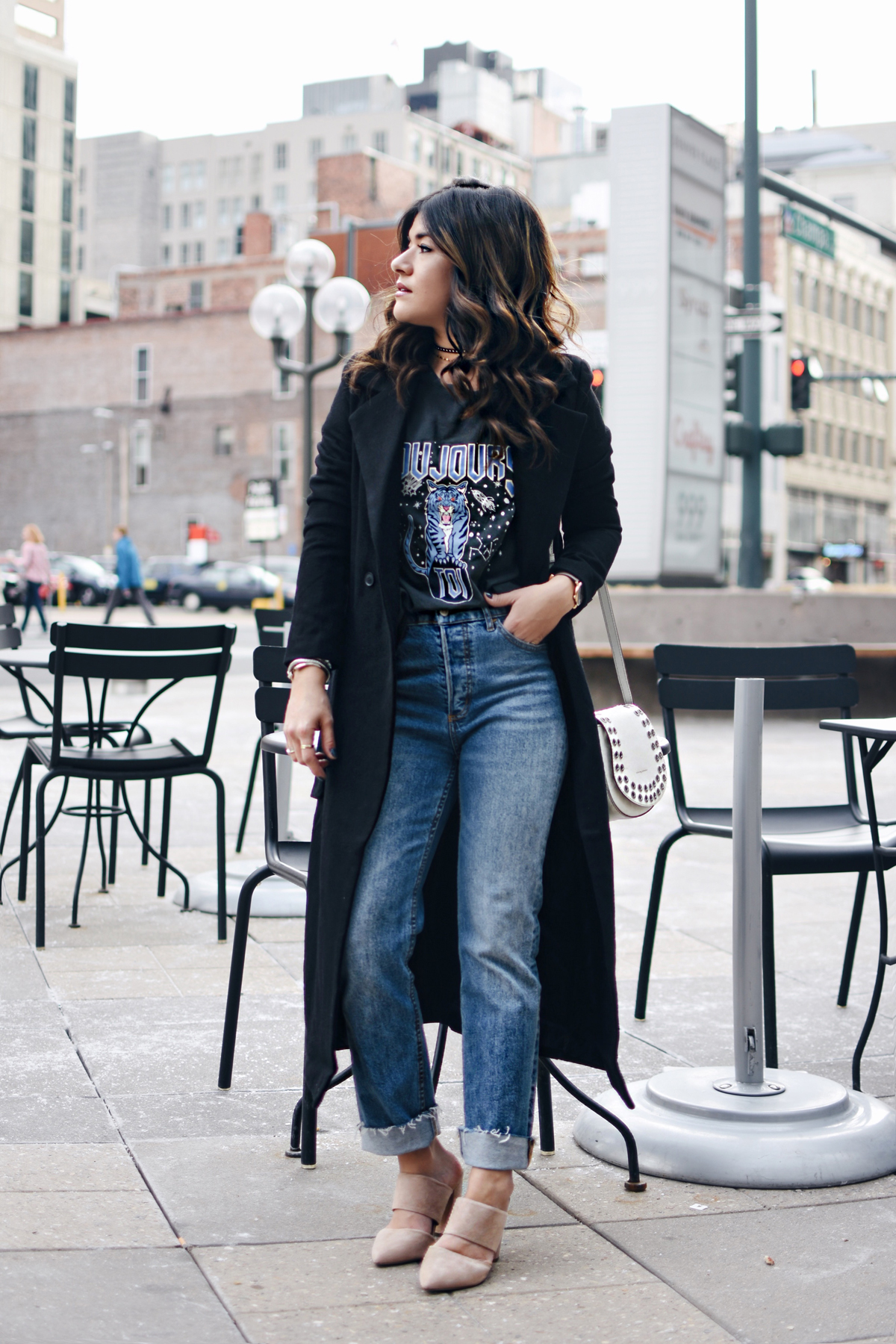 Carolina Hellal of Chic Talk wearing an H&M graphic t-shirt, H&m girlfriend jeans, Frey company white crossbody bag, and NA-KD fashion mules and black coat. - HOW TO STYLE GIRLFRIEND JEANS by popular Denver fashion blogger Chic Talk