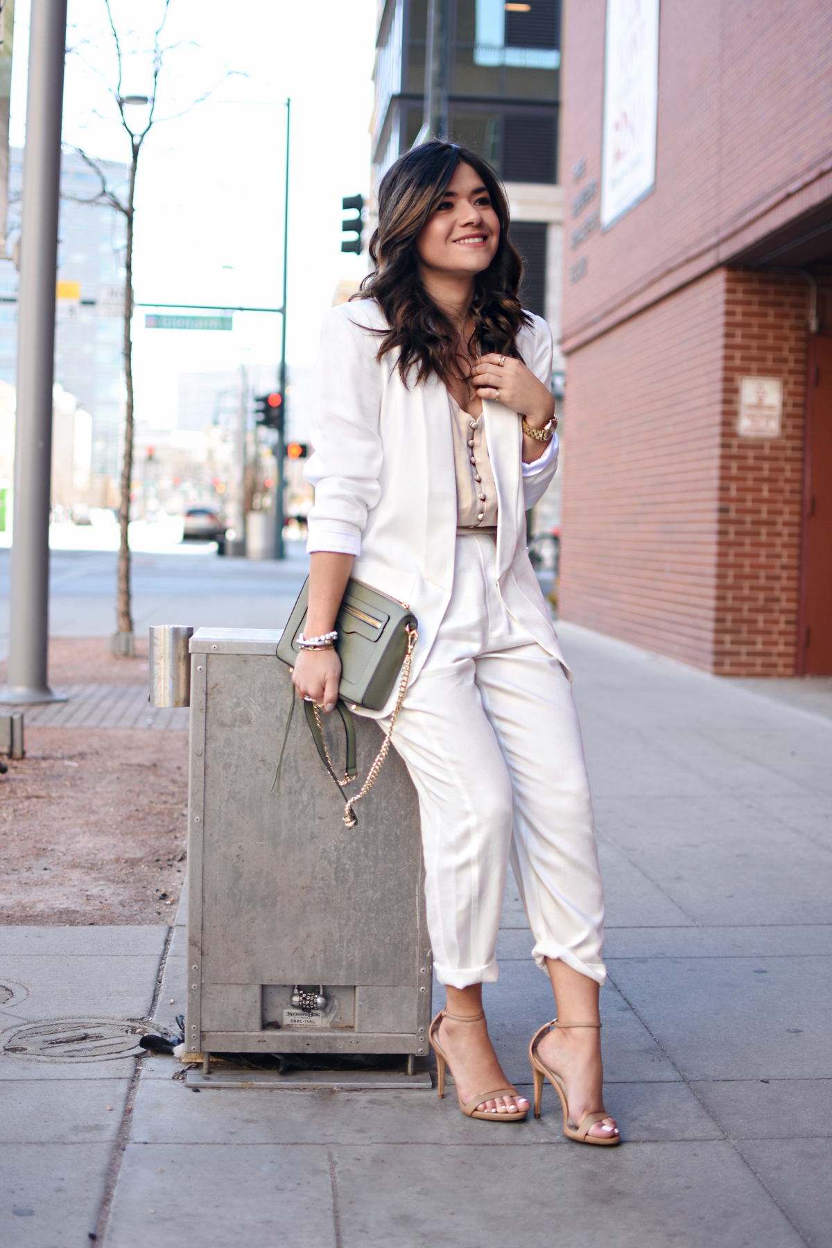 Carolina Hellal of CHIC TALK wearing a white suit via THACKER NYC, a Rebecca Minkoff bag, Steve Madden sandals, and NA-KD nude camisol