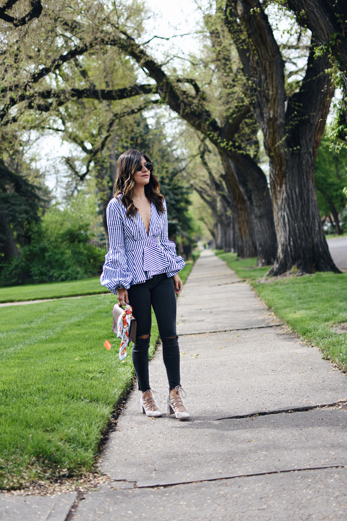 Carolina Hellal wearing a Shein stripe top, Madewell jeans, chinese laundry lace up shoes and rayban sunglasses