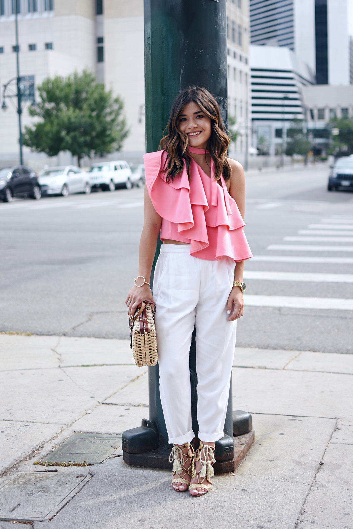Carolina Hellal of Chic Talk wearing an off the shoulder pink ruffle top with white pants, straw bag and MIA lace up heels 