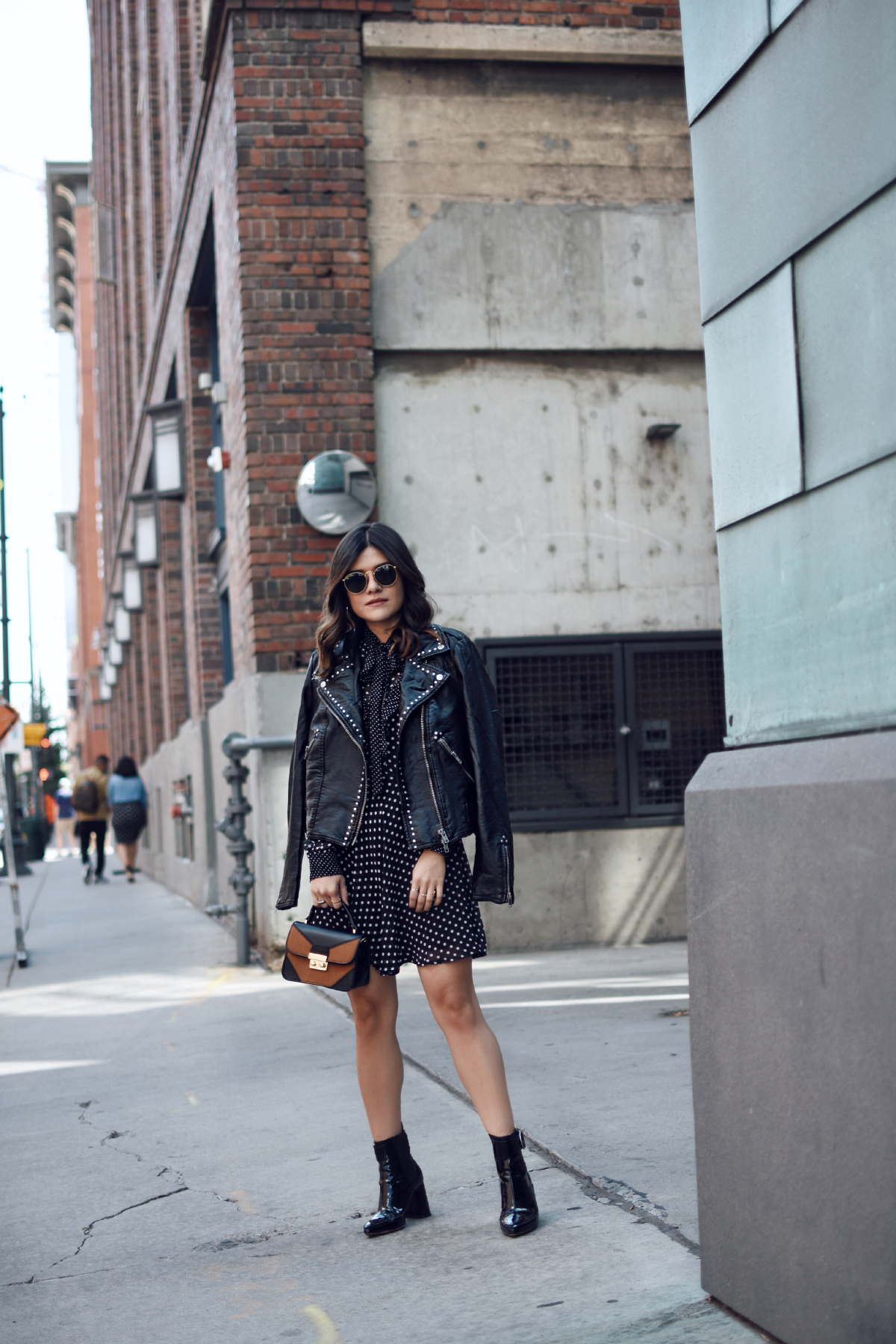 Carolina Hellal of Chic Talk wearing a Free People faux leather jacket, Renamed polka dot dress and h&m black patent leather booties. 