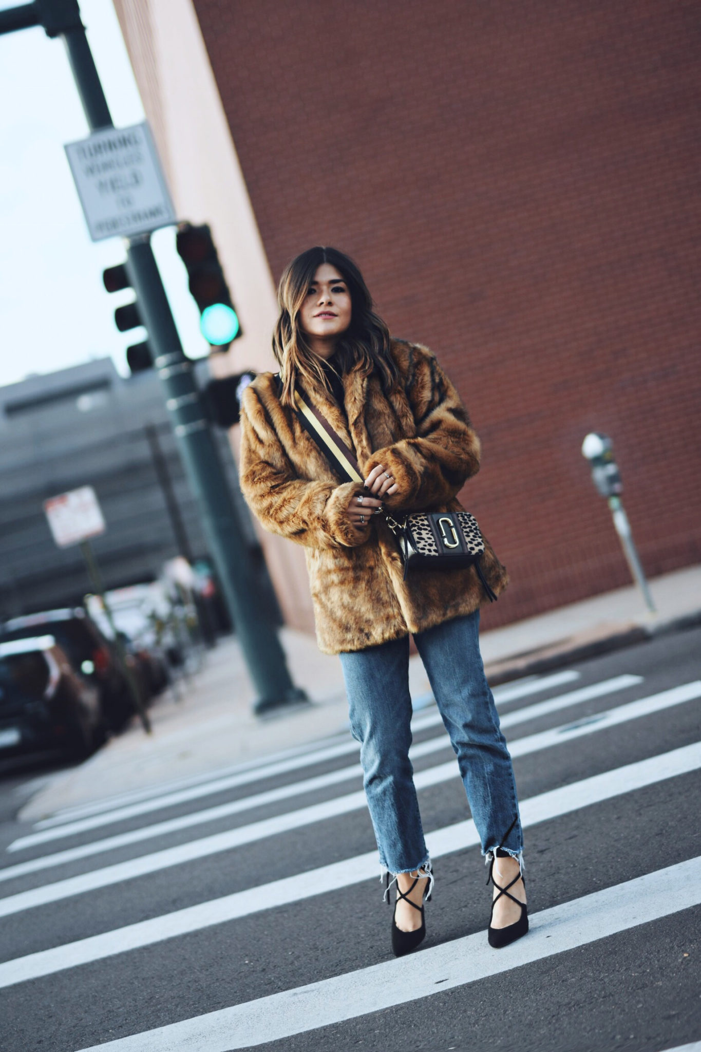 Carolina Hellal of Chic Talk wearing a faux fur coat via ASOS, Levi's jeans, Marc Jacobs crossbody bag and Nine West high heels.