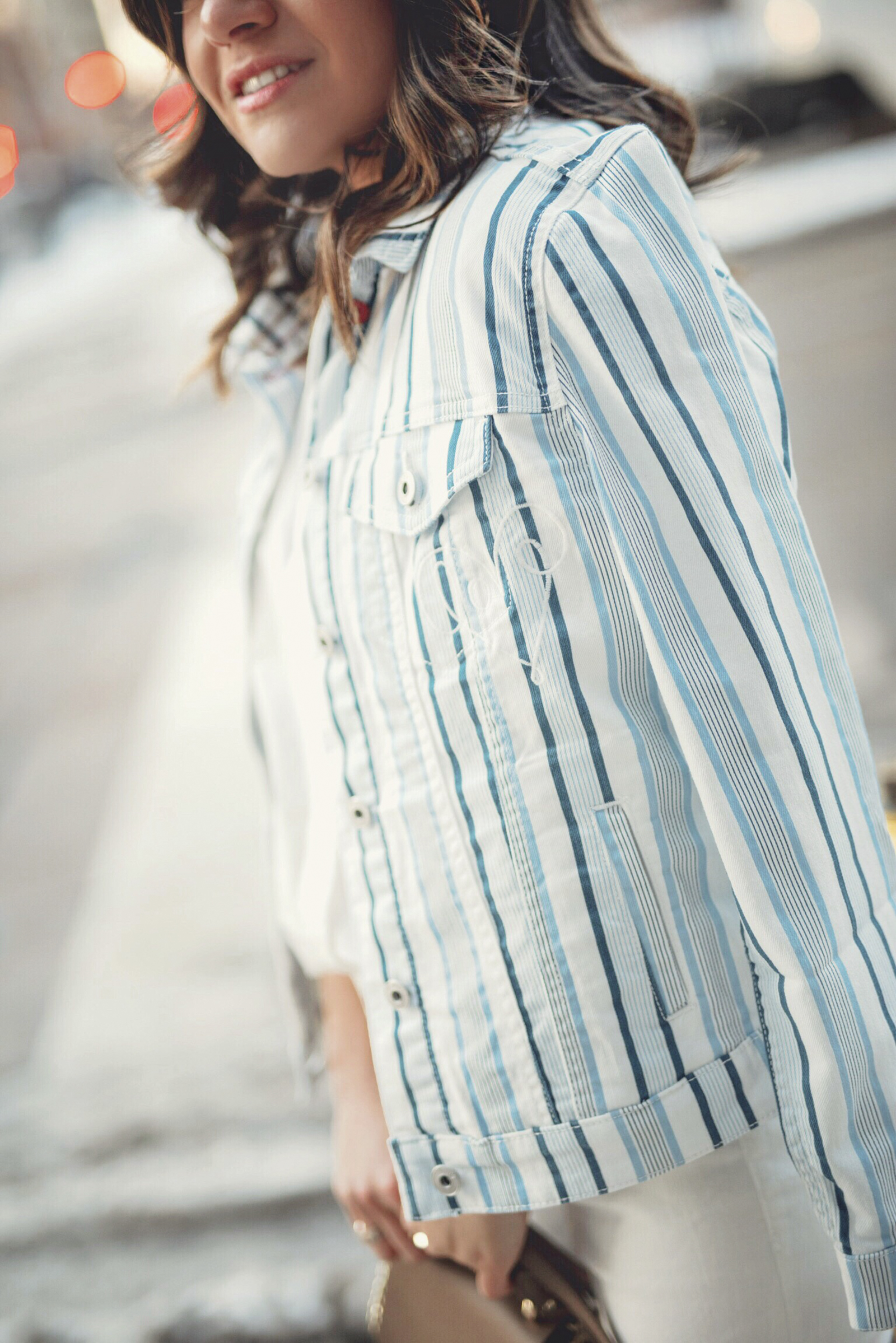 Carolina Hellal of Chic Talk wearing a white button down, white jeans and striped jacket via EV1 a Walmart brand.