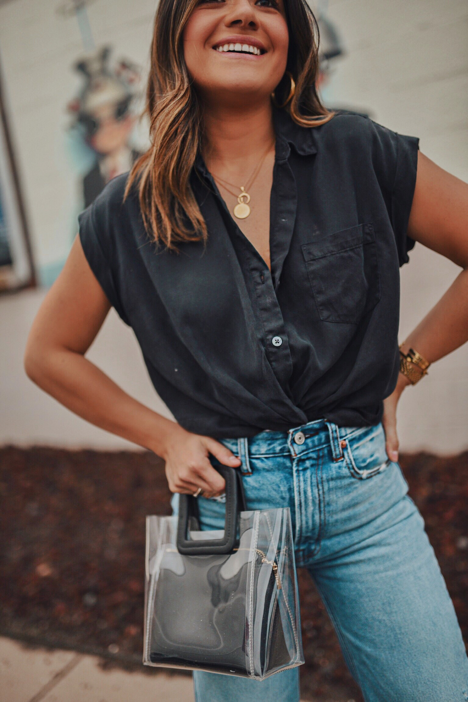 Carolina Hellal of Chic Talk wearing Abercrombie & Fitch wide leg jeans and a black crop shirt, Steve Madden black strap sandals and clear STAUD clothing bag