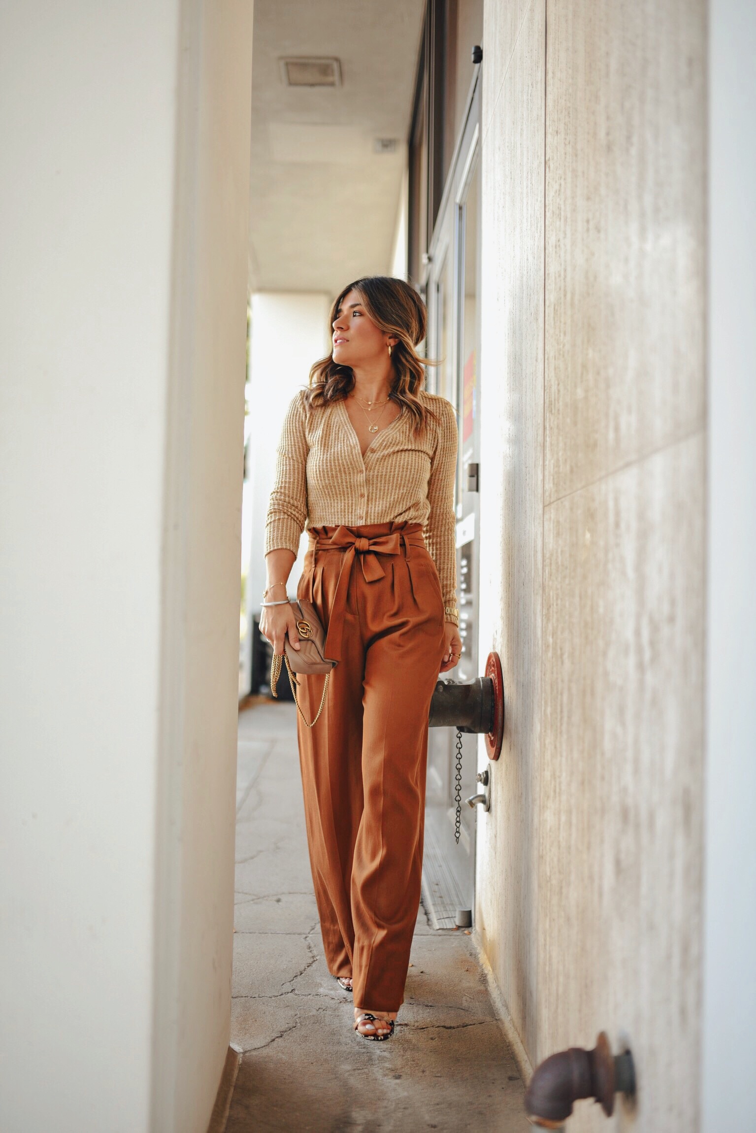 Carolina Hellal of Chic Talk wearing a sweater from the Nordstrom Anniversary Sale, Gucci bag and Sezane high waist pants.