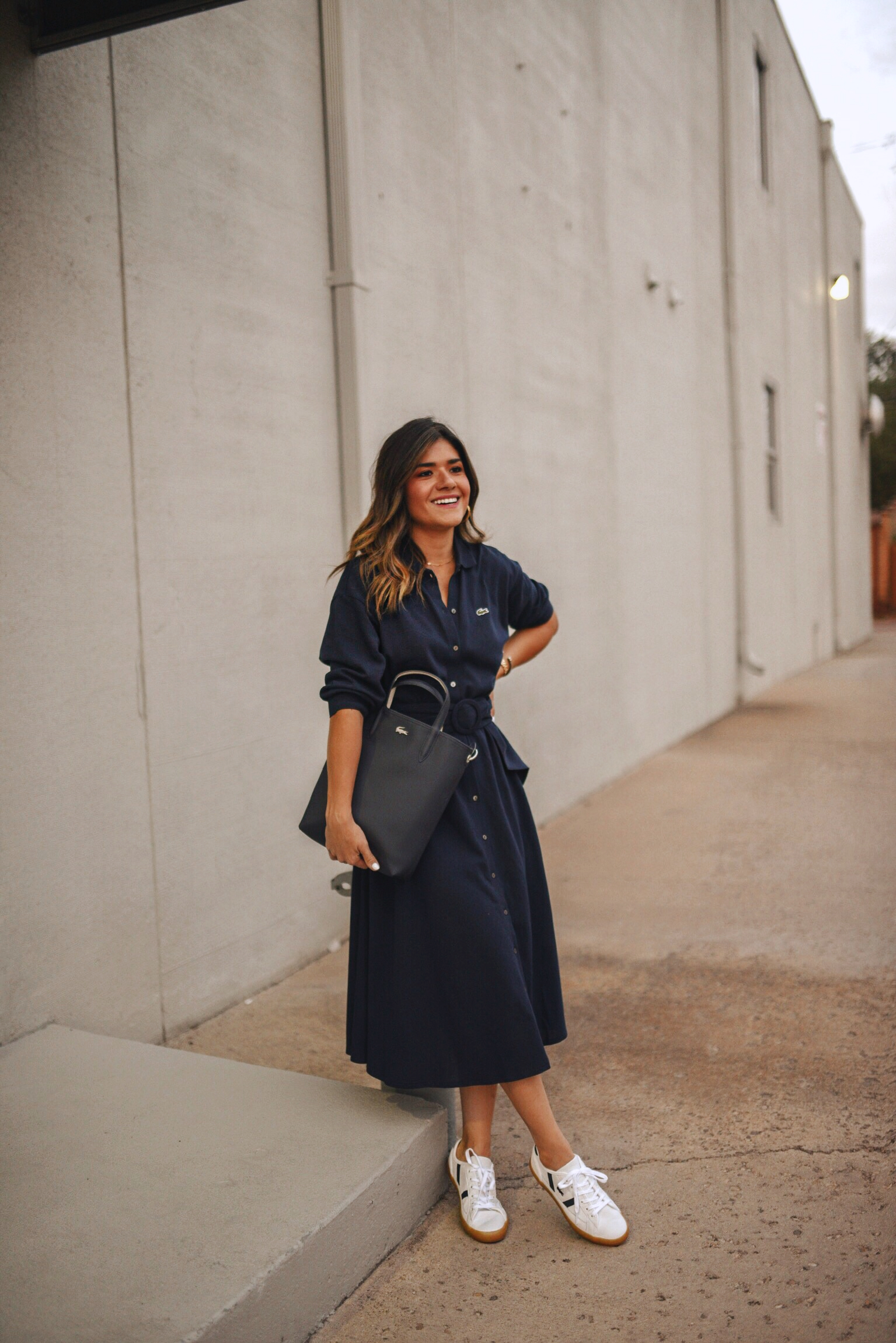 Carolina Hellal of Chic Talk wearing a Lacoste shirtdress, white sneakers and structured bag. 