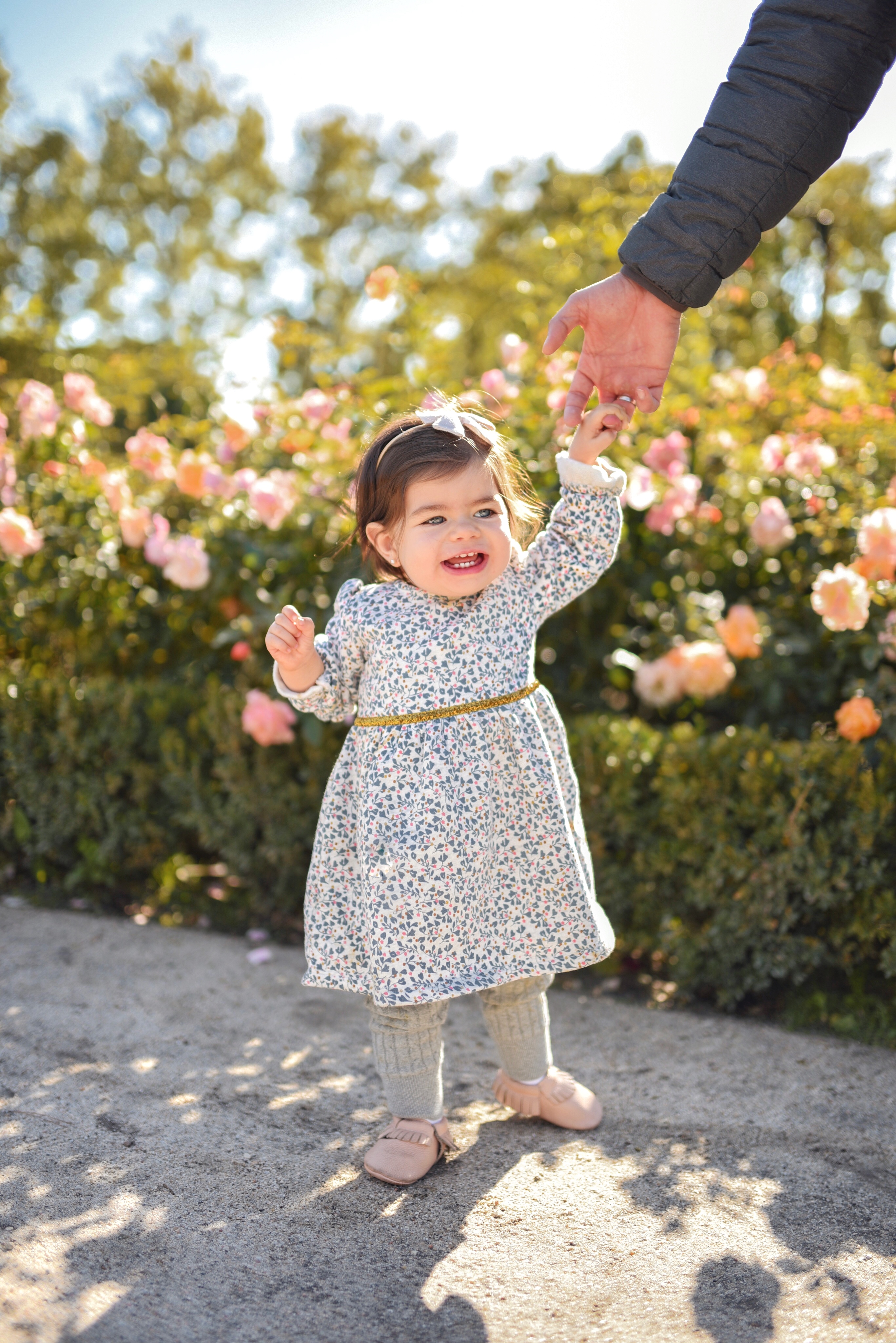 My baby Sofia Jaramillo wearing a floral dress via Carter's, Gap baby knit leggings and pink moccasins via Amazon