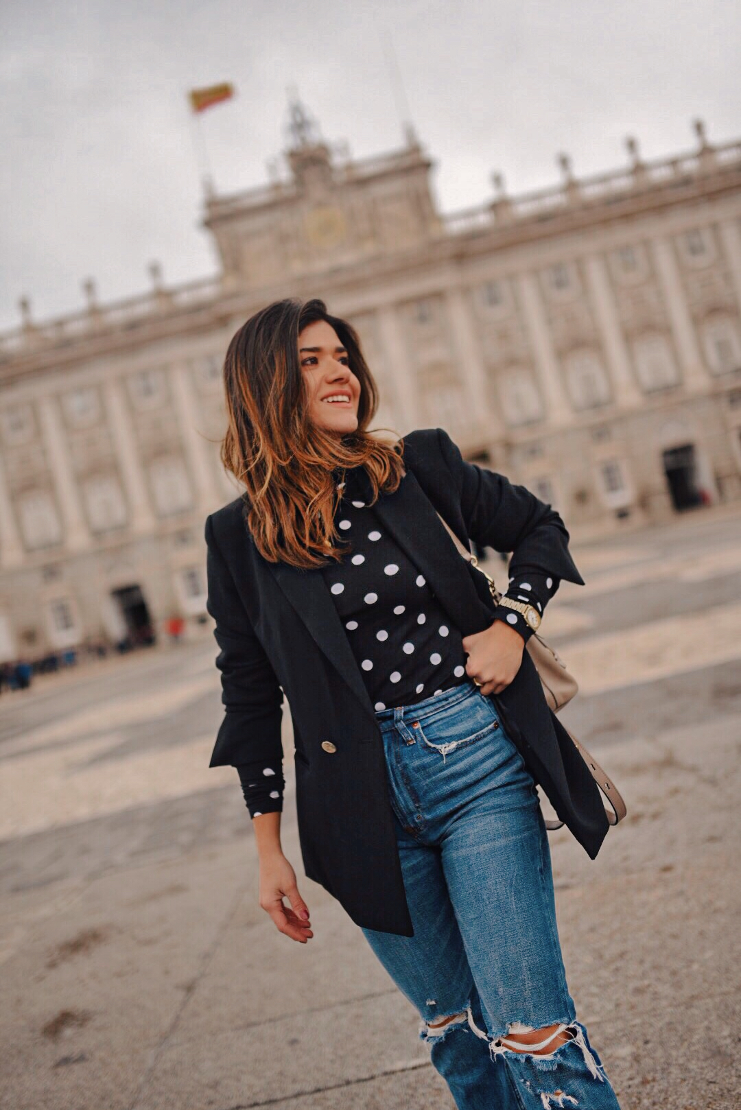 Carolina Hellal of Chic Talk wearing an H&M black blazer, polka dot turtle neck sweater, Abercrombie ripped jeans, Chloé backpack and Vici dolls beige booties in Madrid, Spain