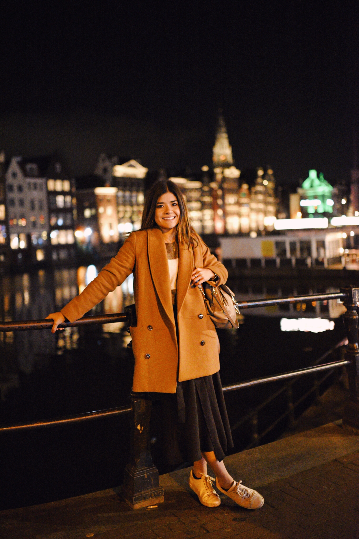 carolina Hellal of Chic Talk in Amsterdam wearing a Sezane camel coat, striped sweater, black wrap skirt and Chloé backpack. 