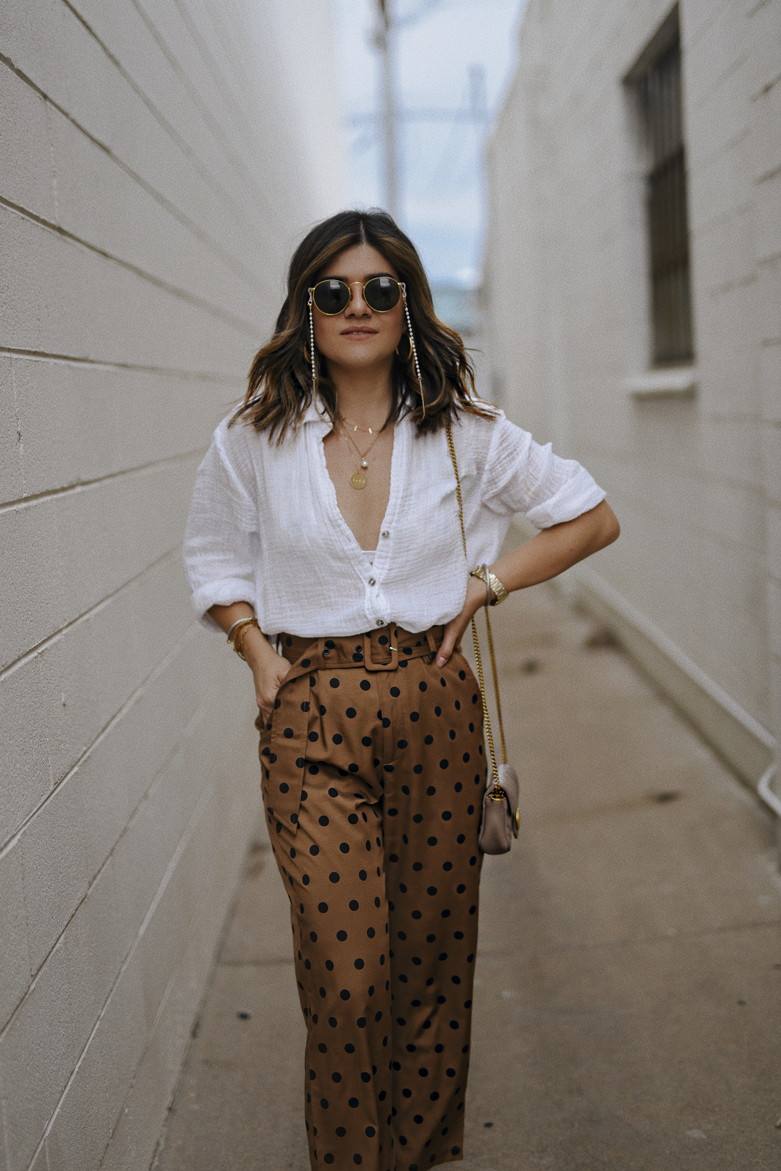 Carolina Hellal of Chic Talk wearing a Michael Stars white button down shirt, Lucy Paris polka dot pants , Gucci handbag and Rayban rounded sunglasses. 