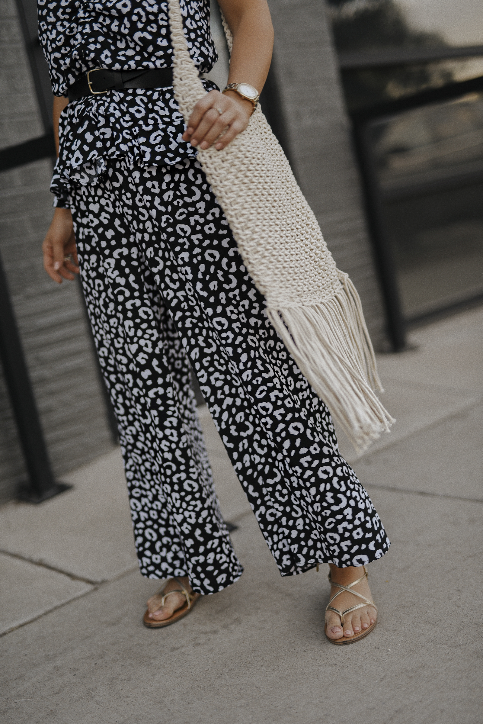 Carolina Hellal of Chic Talk wearing a Scoop printed top, wide leg pants, lace up sandals and knit mochila via Walmart. 