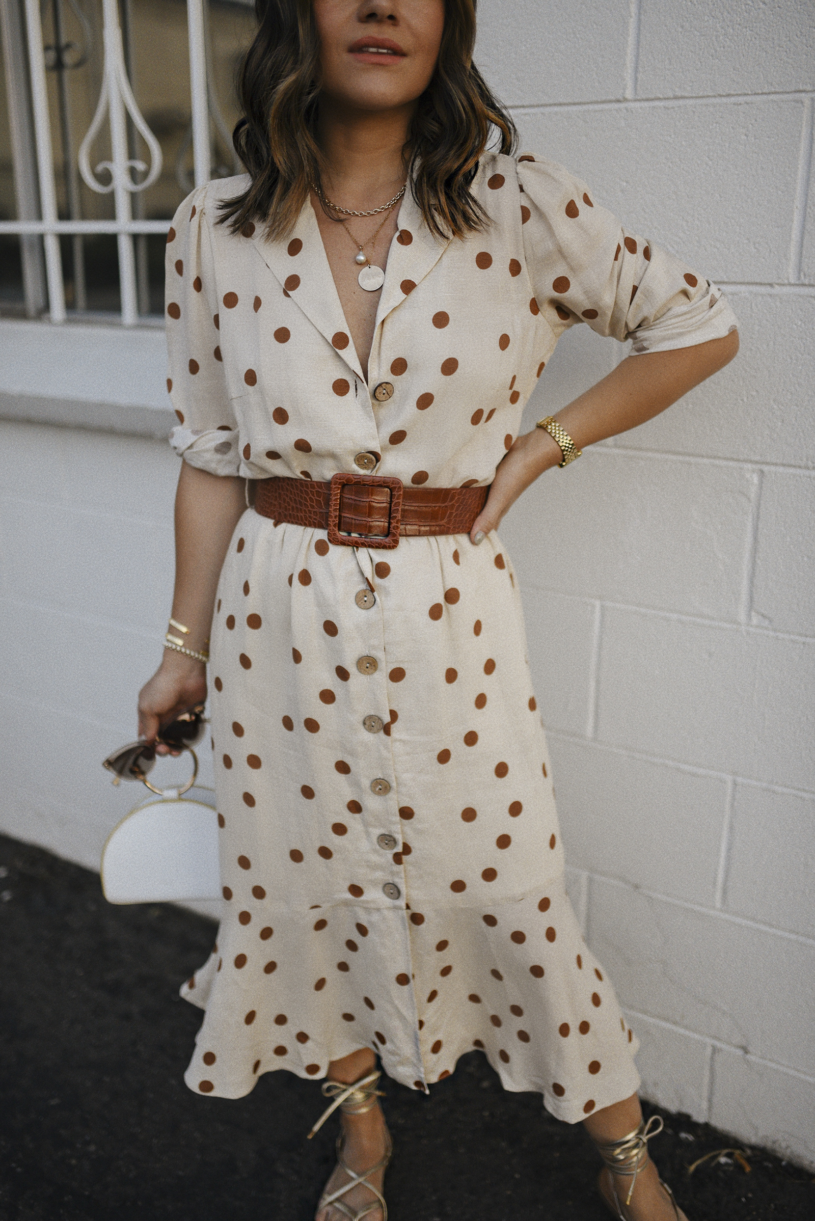 Carolina Hellal of Chic Talk wearing a Lucy Paris Polka dot midi dress, Irridescense white bag, Scoop gold lace up sandals and RAEN sunglasses