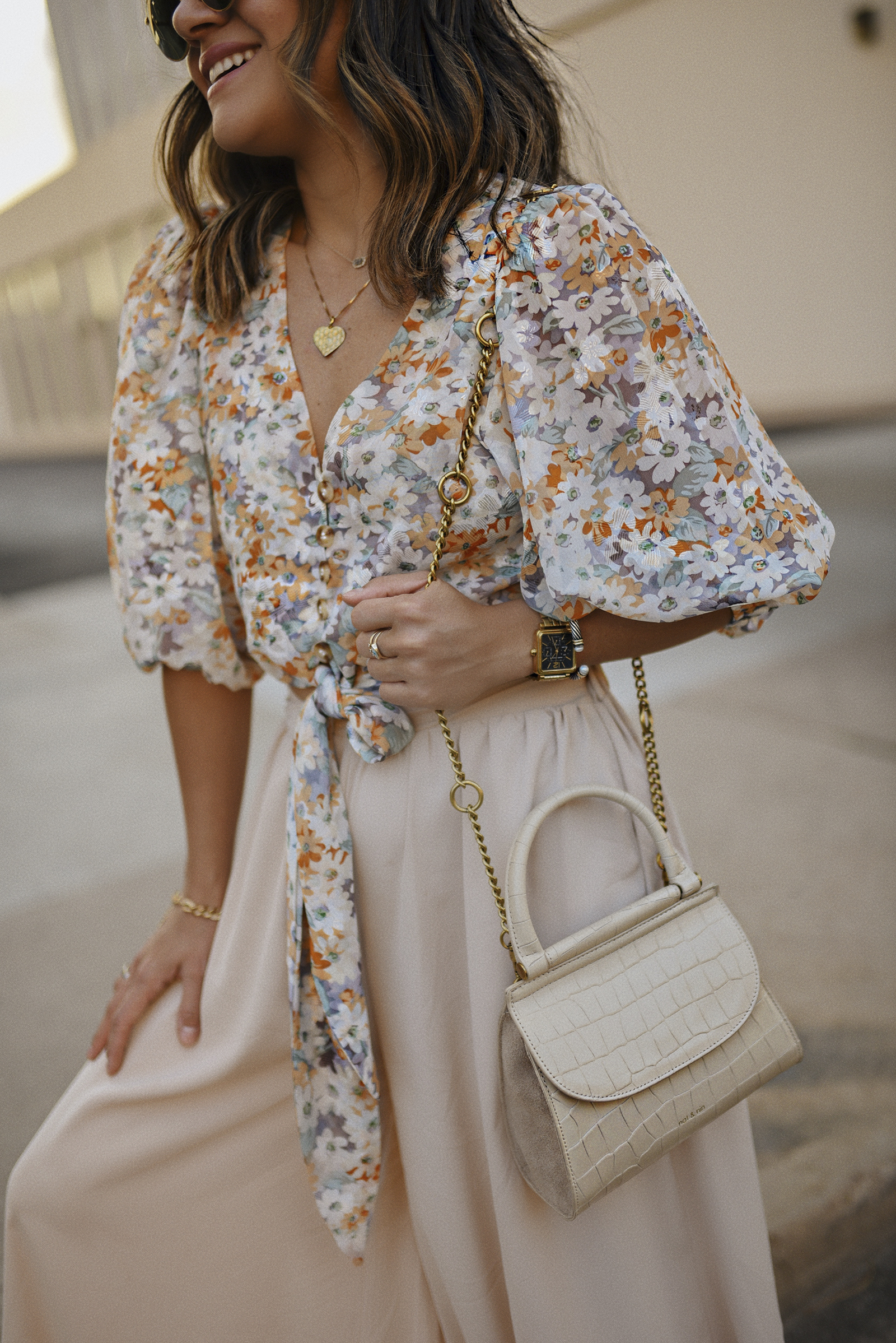 Carolina Hellal of Chic Talk wearing a Chicwish Floral front tie top, nude wide leg pants, Rayban sunglasses, Urban Outfitters sandals and Nat & Nin beige crosssbody bag.
