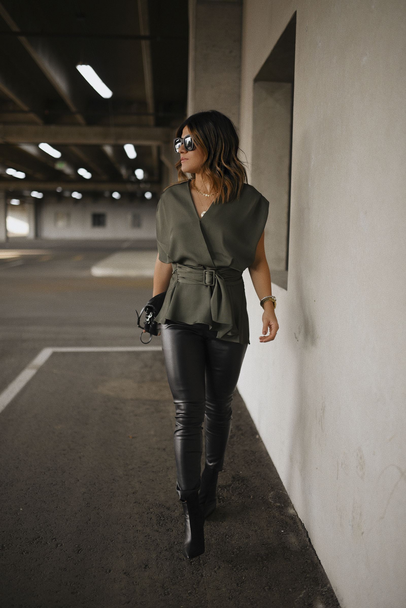 Carolina Hellal of Chic Talk wearing an Express wrap top, Sofia Jeans Faux leather pants, Lafayette148 black booties and a YSL crossbody bag. 