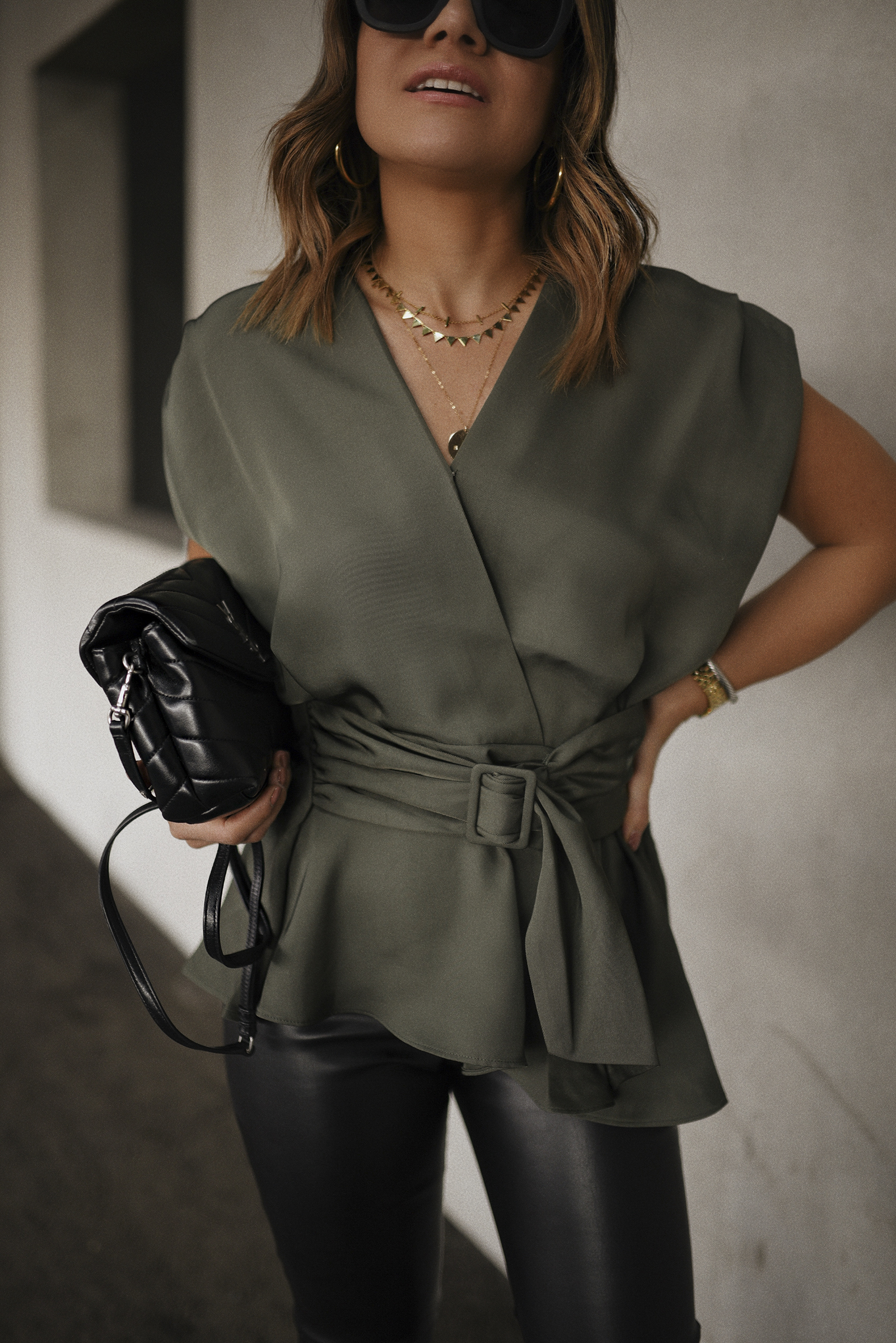 Carolina Hellal of Chic Talk wearing an Express wrap top, Sofia Jeans Faux leather pants, Lafayette148 black booties and a YSL crossbody bag. 