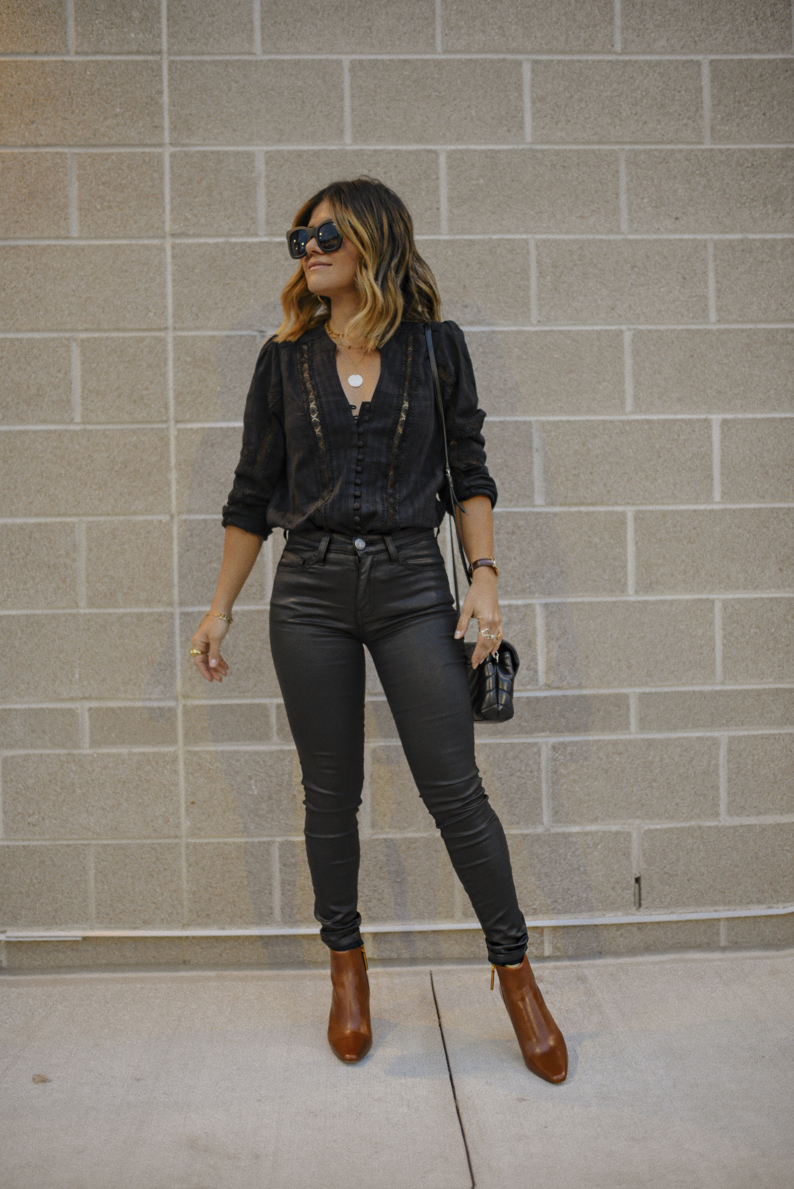 Carolina Hellal of Chic Talk wearing a Heartloom black top, current Elliot black coated jeans, Louise et cie booties and a YSL crossbody bag. 