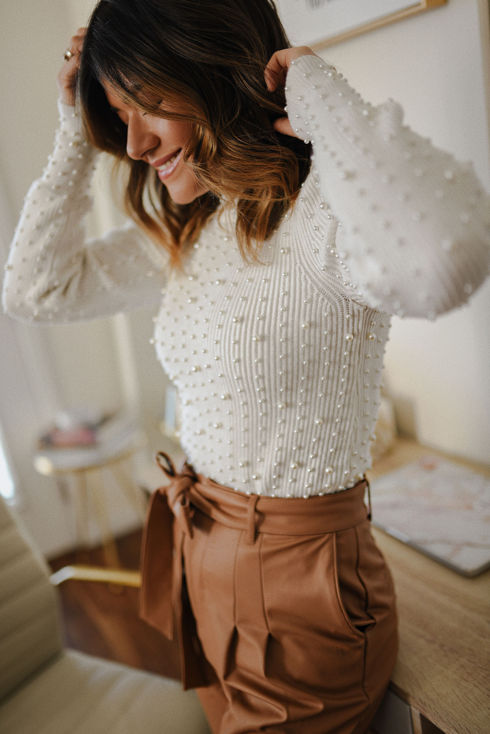 Carolina Hellal of Chic Talk wearing a sweater with pearl details, vegan leather pants via Express. 