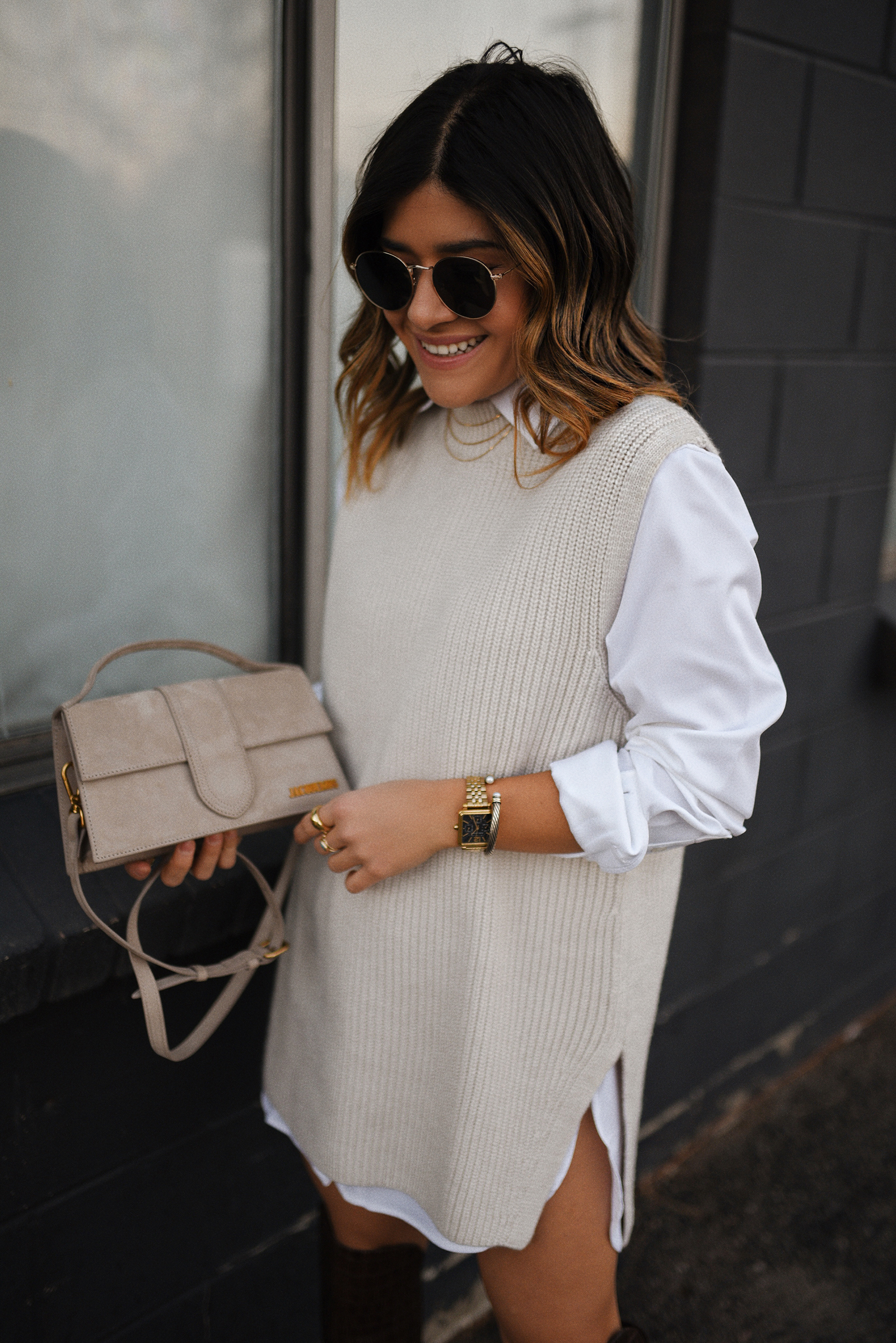 Carolina Hellal of Chic Talk wearing an H&M sleeveless knit sweater, LEZE white button down, Jacquemus Le Bambino bag and Vince Camuto tall croc embossed boots. 