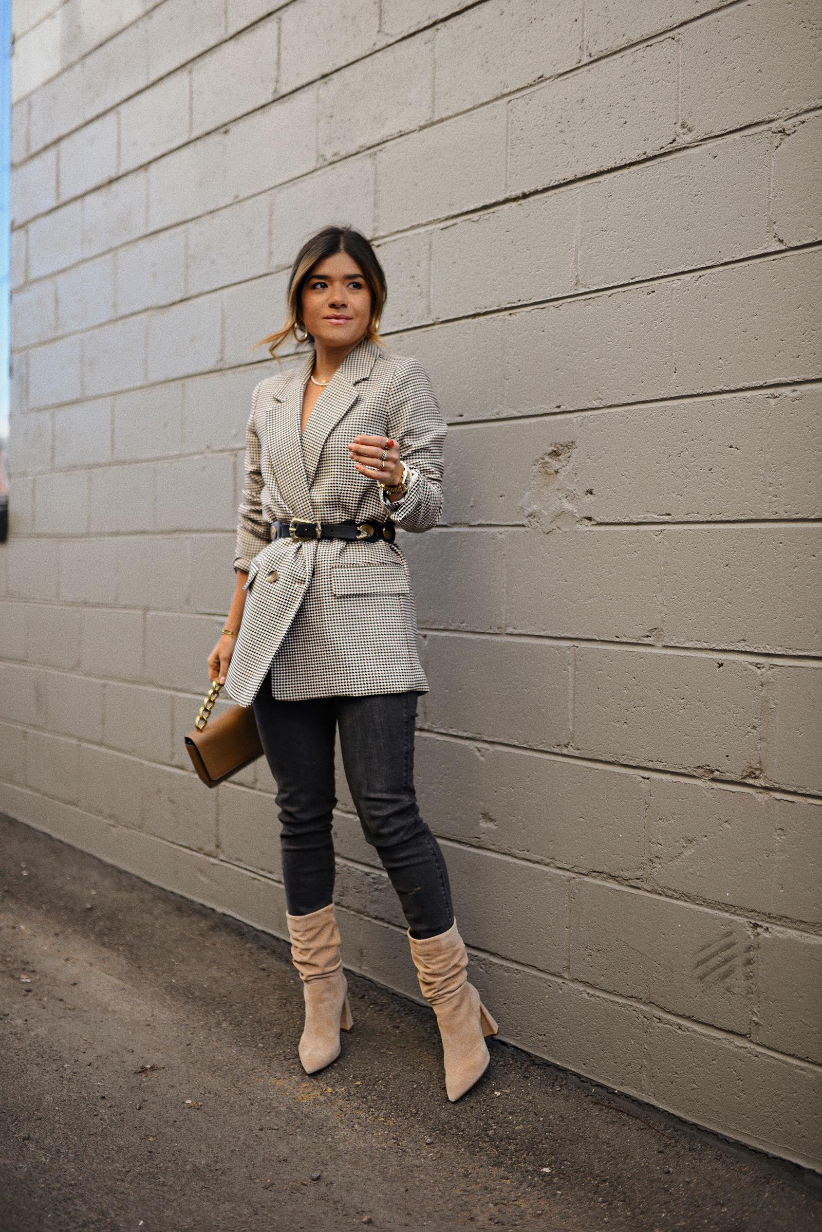 Carolina Hellal of Chic Talk wearing a plaid blazer via H&M, Jbrand grey jeans, Vince Camuto suede beige boots, Sezane western belt and Scoop brown bag via Walmart 