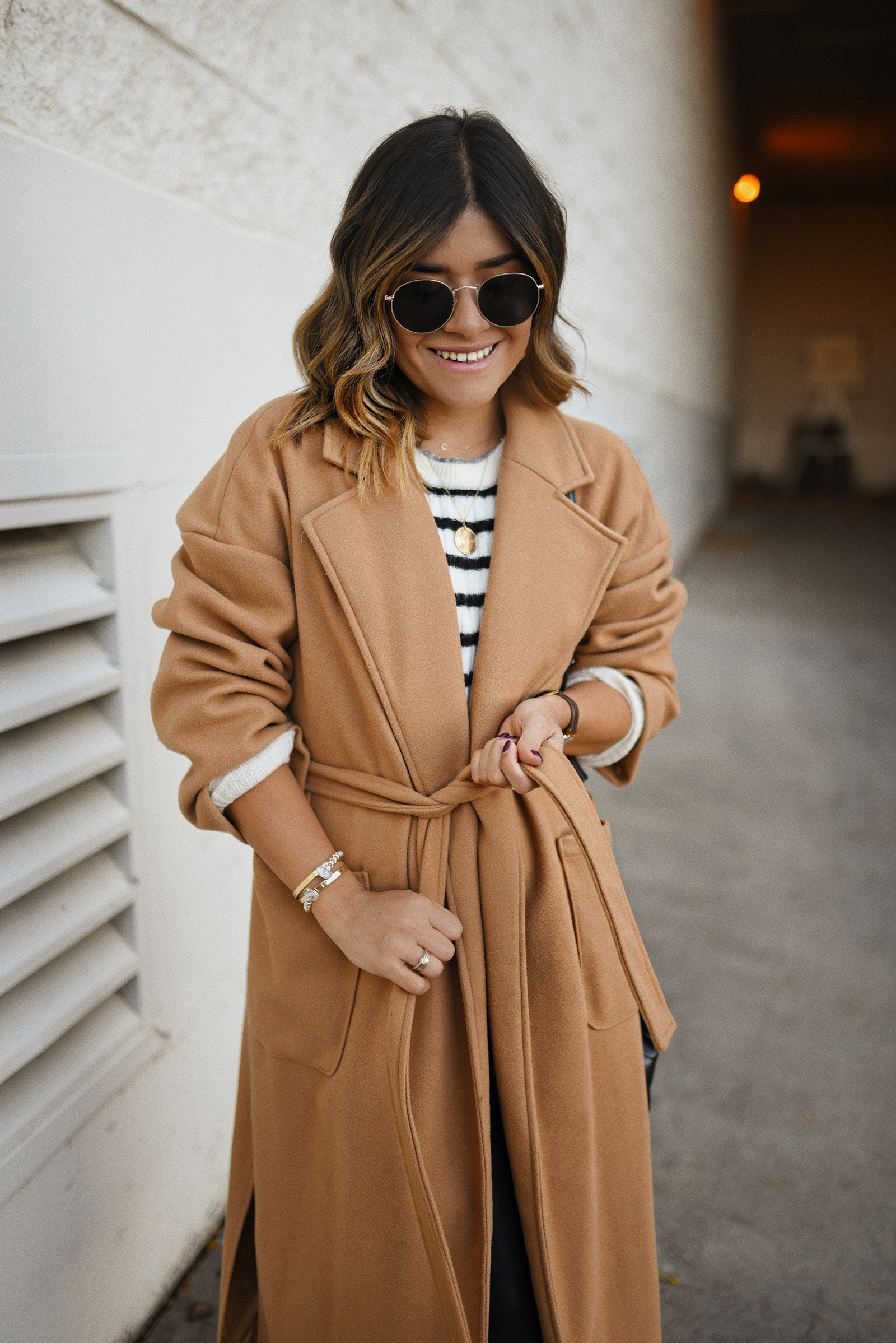 Carolina Hellal of Chic Talk wearing a Shein camel coat, H&M nautical sweater, Spanx faux leather leggings and Vince Camuto black chunky boots.