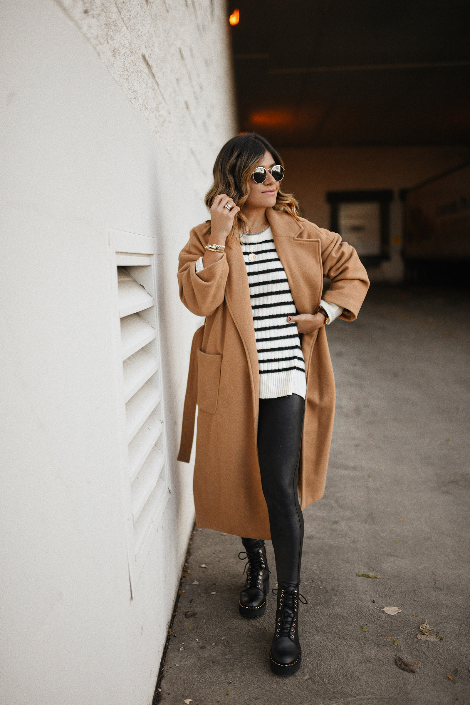 Carolina Hellal of Chic Talk wearing a Shein camel coat, H&M nautical sweater, Spanx faux leather leggings and Vince Camuto black chunky boots.