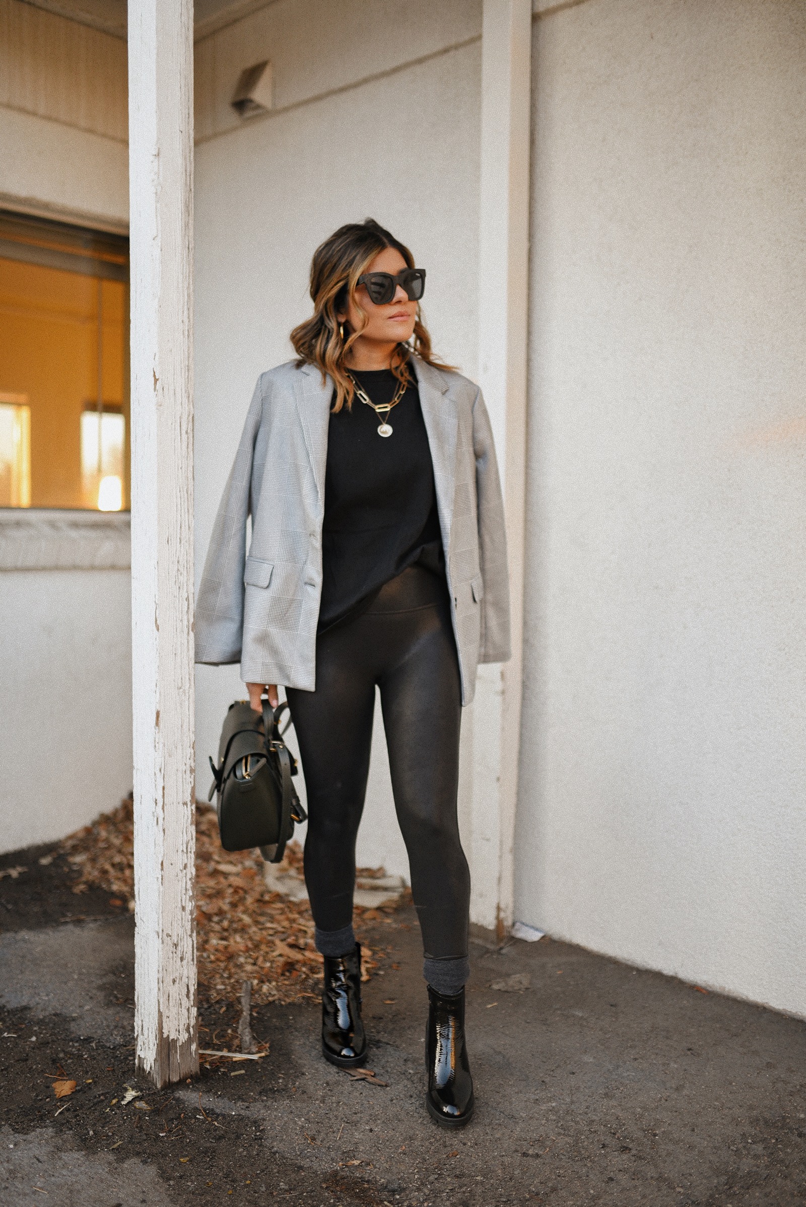 Carolina Hellal of Chic Talk wearing a Lezé de Label plaid blazer, black muscle tee, spanx faux leather leggings, Senreve bag and Naturalizer black booties.