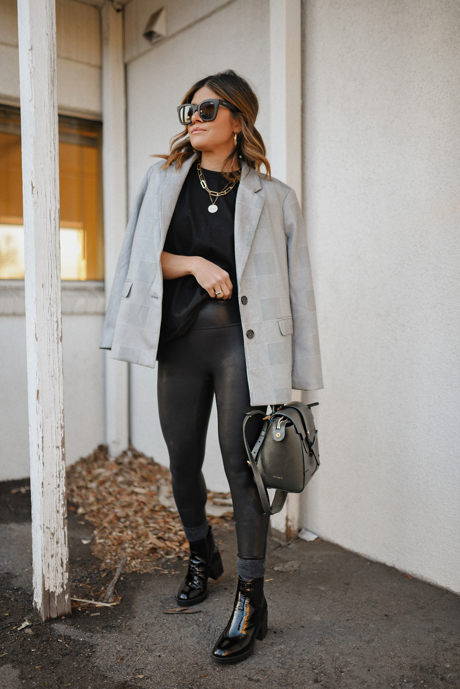 Carolina Hellal of Chic Talk wearing a Lezé de Label plaid blazer, black muscle tee, spanx faux leather leggings, Senreve bag and Naturalizer black booties.