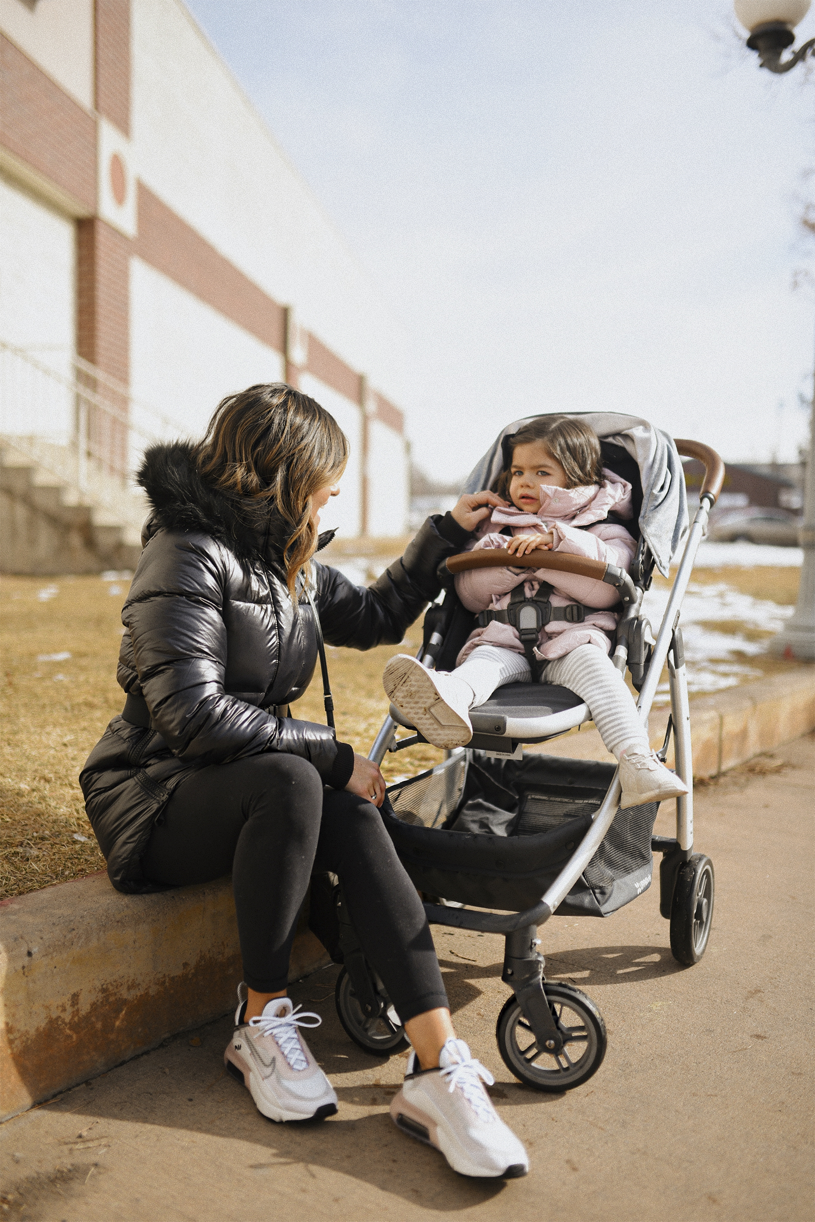 Carolina Hellal of Chic Talk wearing a The North Face back parka, Lulumeno black leggins, Nike Air Max 2090. Her daughter is in the Uppa Baby Cruz stroller.