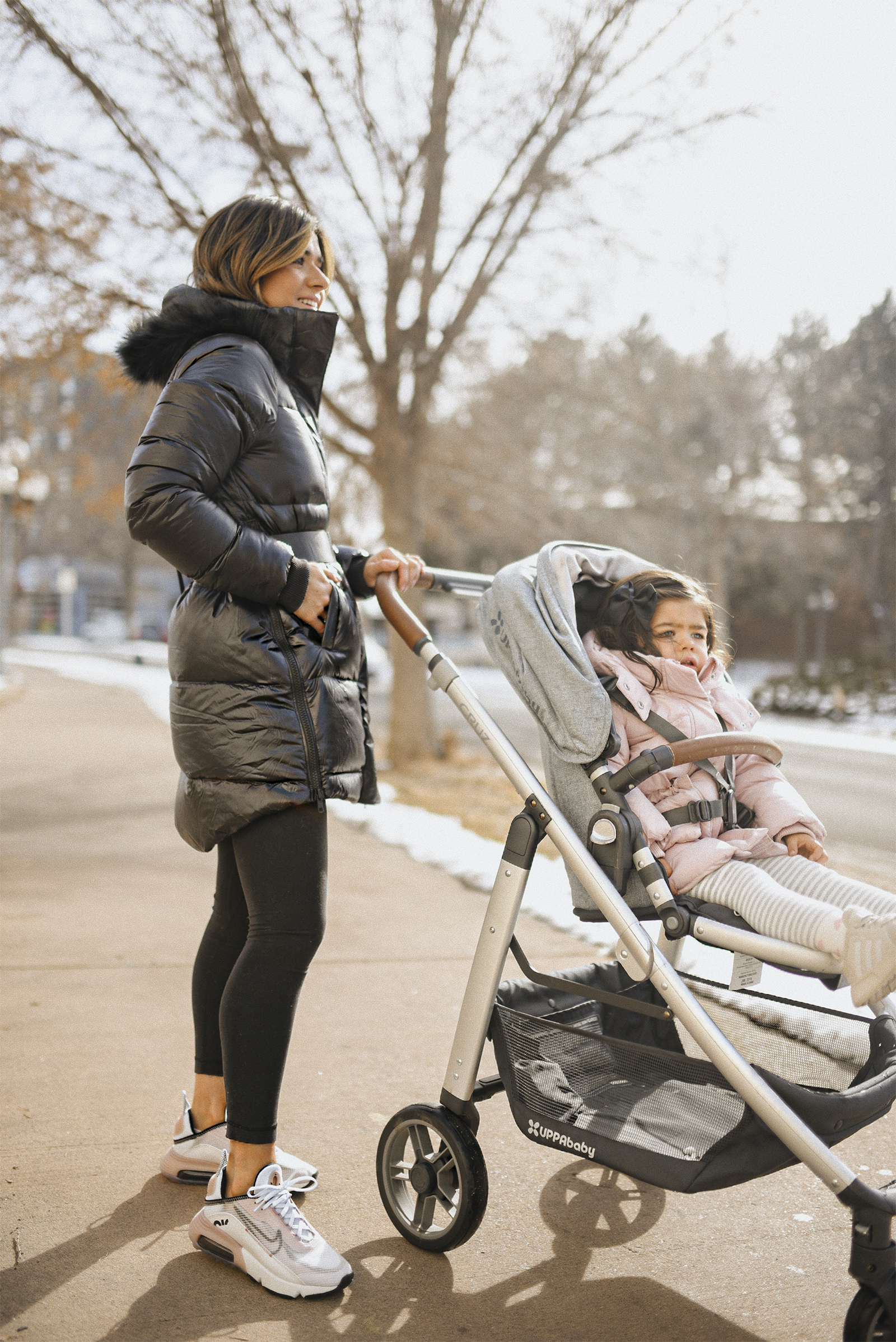 Carolina Hellal of Chic Talk wearing a The North Face back parka, Lulumeno black leggins, Nike Air Max 2090. Her daughter is in the Uppa Baby Cruz stroller.