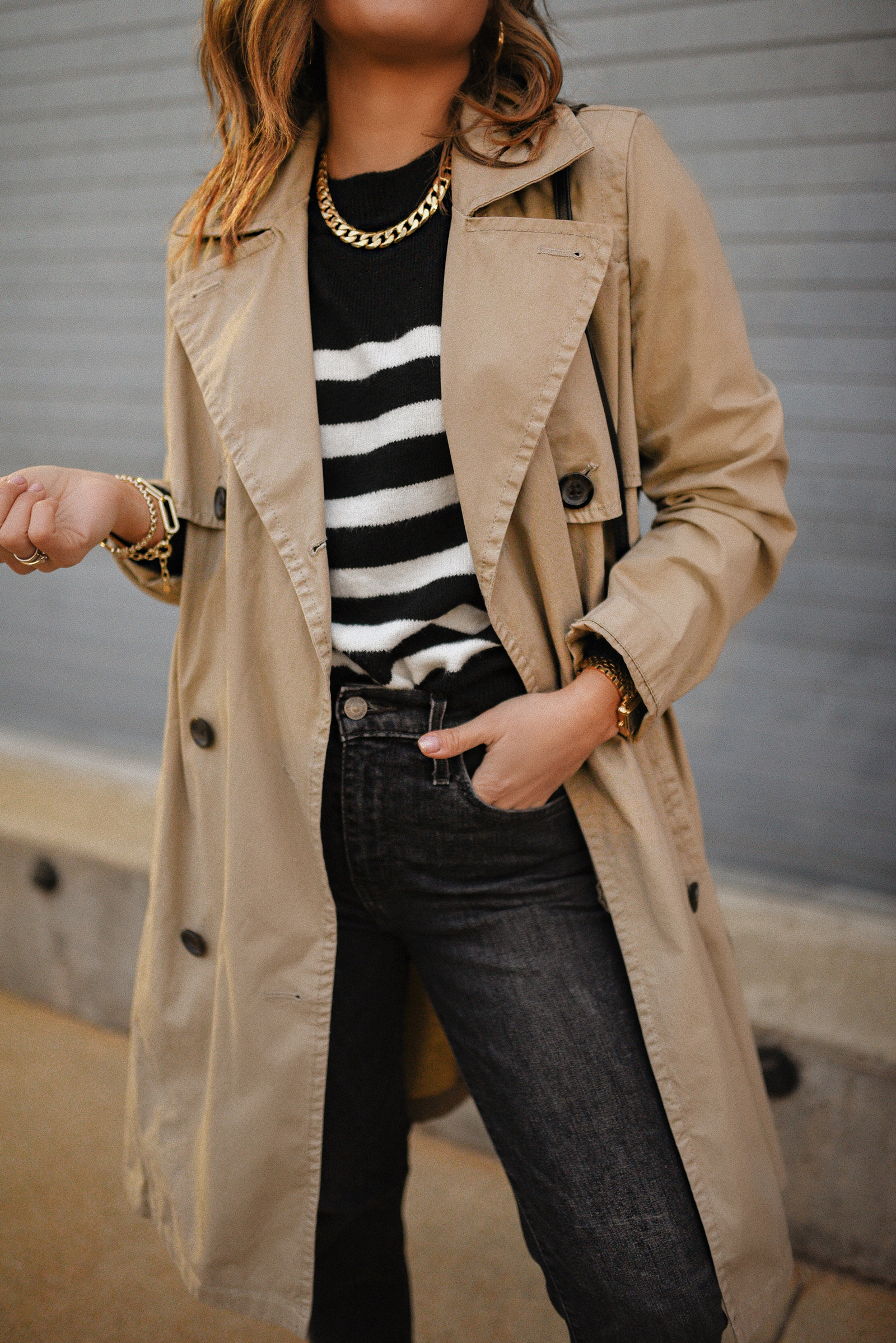 Carolina Hellal of Chic Talk wearing a Madewell trench coat, H&M striped sweater, Levi's grey jeans, Vince Camuto flats and YSL crossbody bag. 