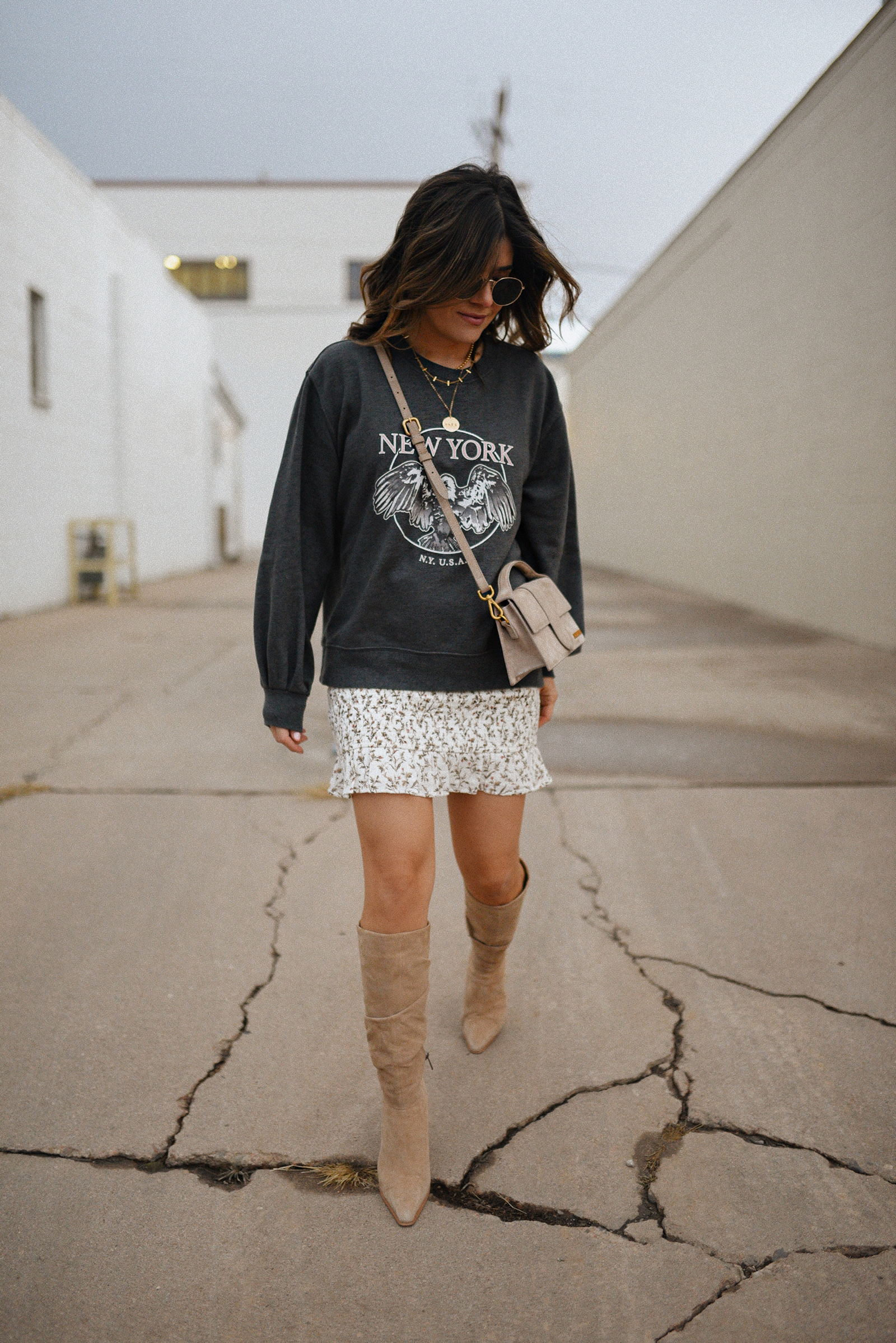 Carolina Hellal of Chic Talk wearing an Abercrombie sweatshirt, mini floral skirt, Vince Camuto suede tall boots and Jacquemus le bambino bag. 