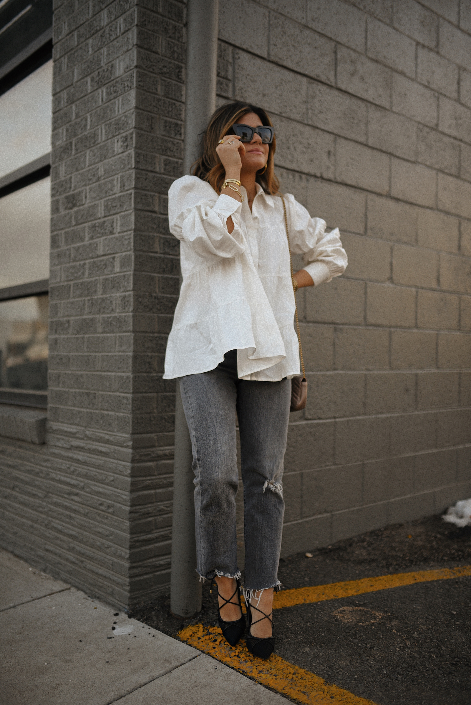 Carolina Hellal of Chic Talk wearing a WAYF white oversized top, Levi's grey straight leg jeans and JLO Jennifer Lopez black lace-up pumps