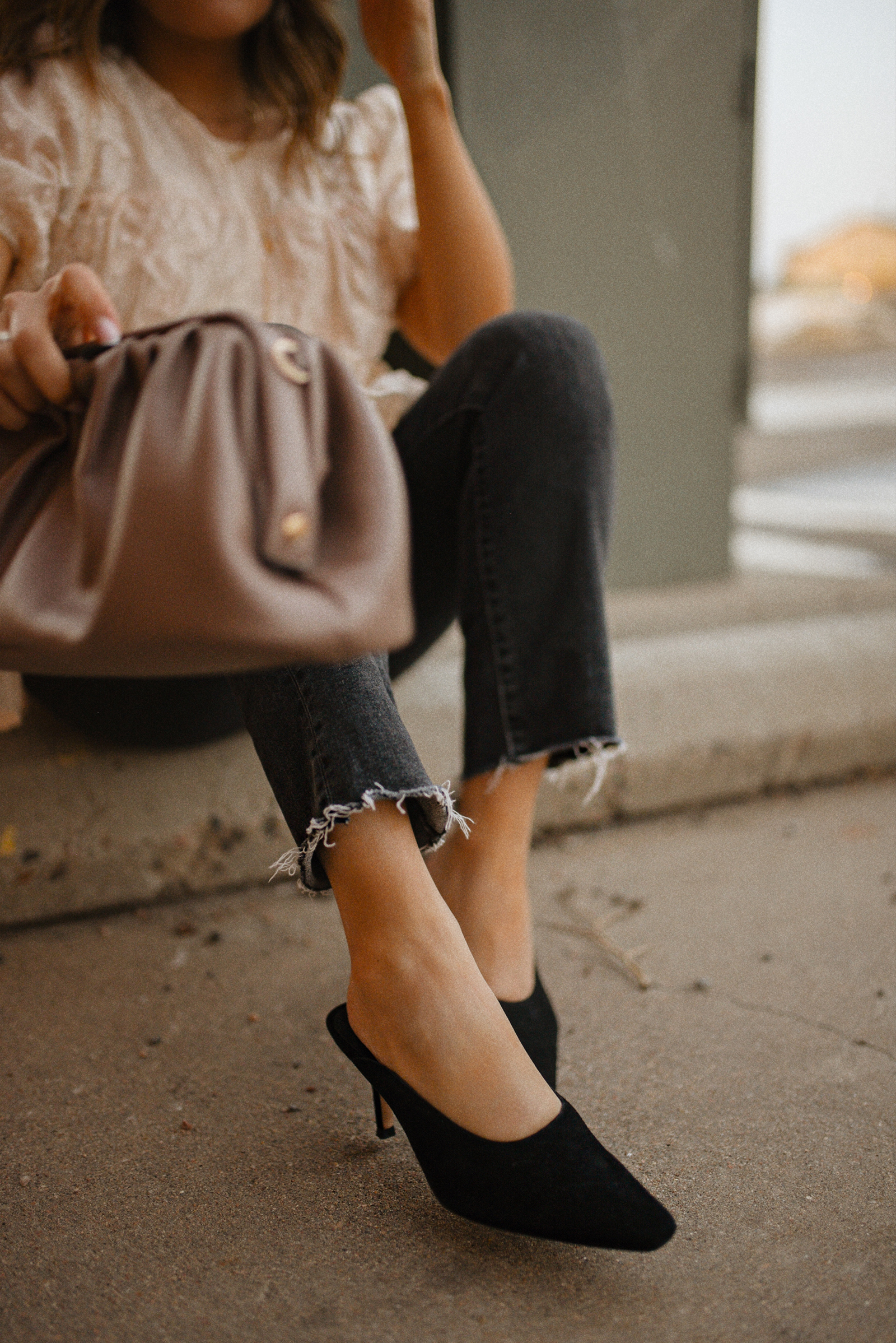 Carolina Hellal of Chic Talk wearing a floral A-line blouse, Levi's grey straight leg jeans, Quay eye cat sunglasses and Pelle moda black mules and Target pouch bag. 