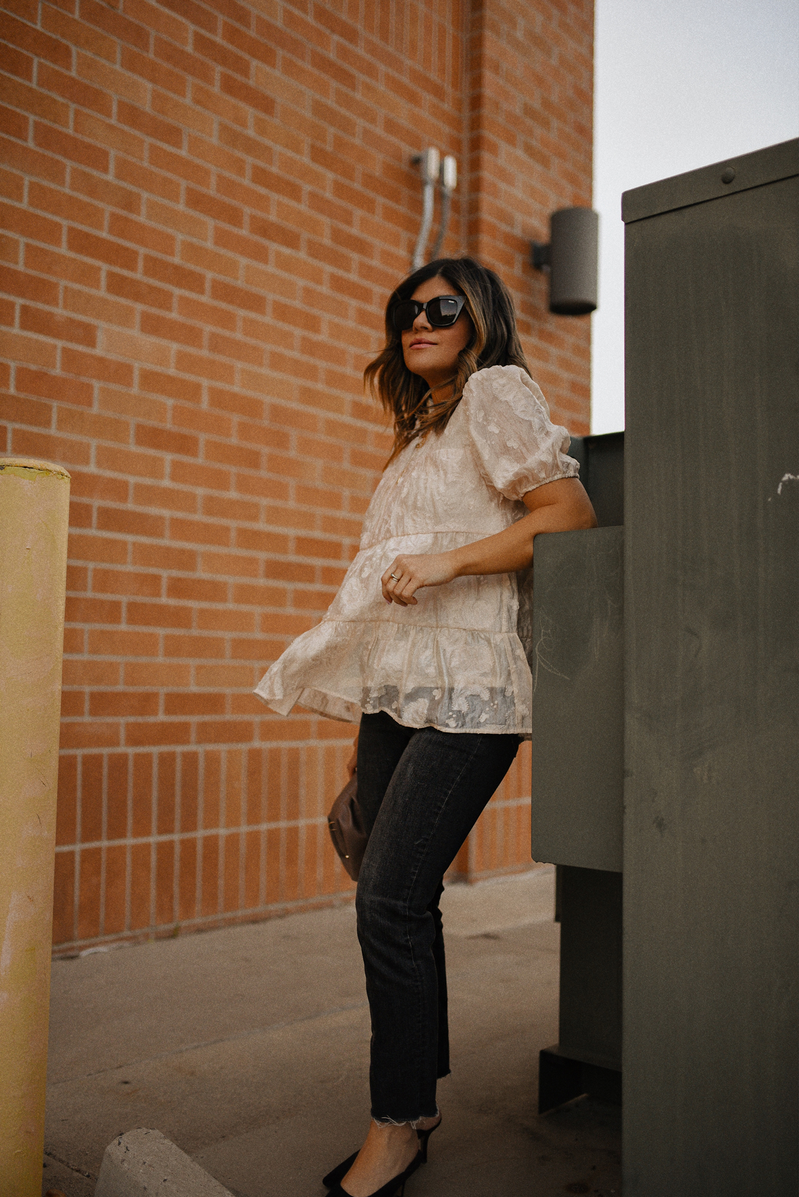 Carolina Hellal of Chic Talk wearing a floral A-line blouse, Levi's grey straight leg jeans, Quay eye cat sunglasses and Pelle moda black mules and Target pouch bag. 